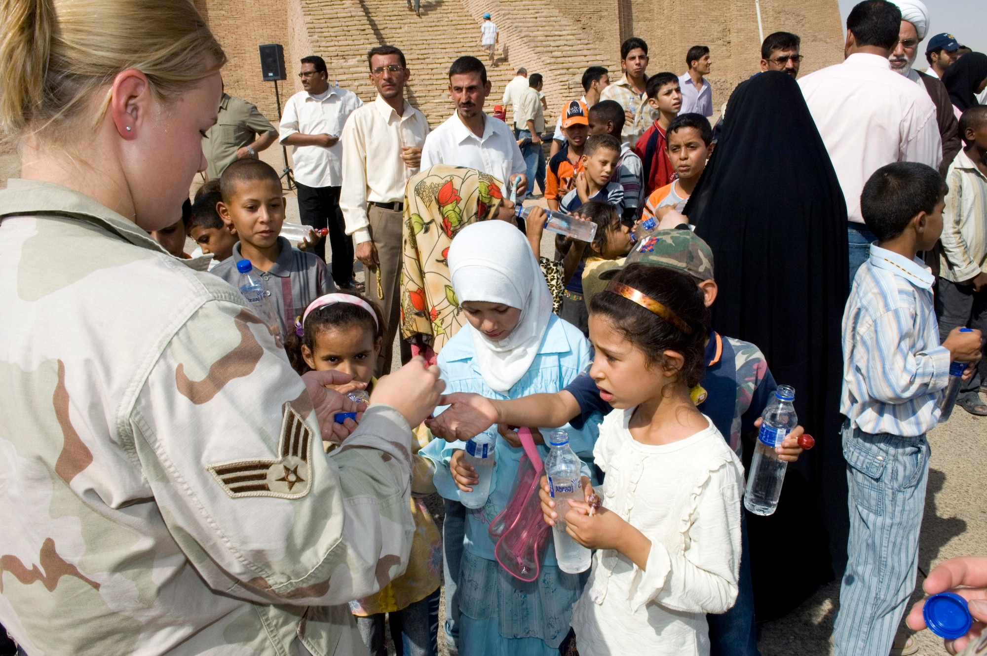 Senior Airman Ashley-Louise Jacobsen passes out candy to young Iraqi children during a visit by 80 Iraqi nationals to the historical Ziggurat Aug. 21 located on Ali Base, Iraq. The Ali First Four Council sponsored the visit. This is the first time in more than 10 years that Iraqi civilians have been allowed to step on the grounds of the historical site, which was built in the ancient city of Ur and includes the house of the biblical prophet Abraham. Airman Jacobsen is a member of the 407th Expeditionary Logistics Readiness Squadron at Ali Base. (U.S. Air Force photo/Master Sgt. Robert W. Valenca) 
