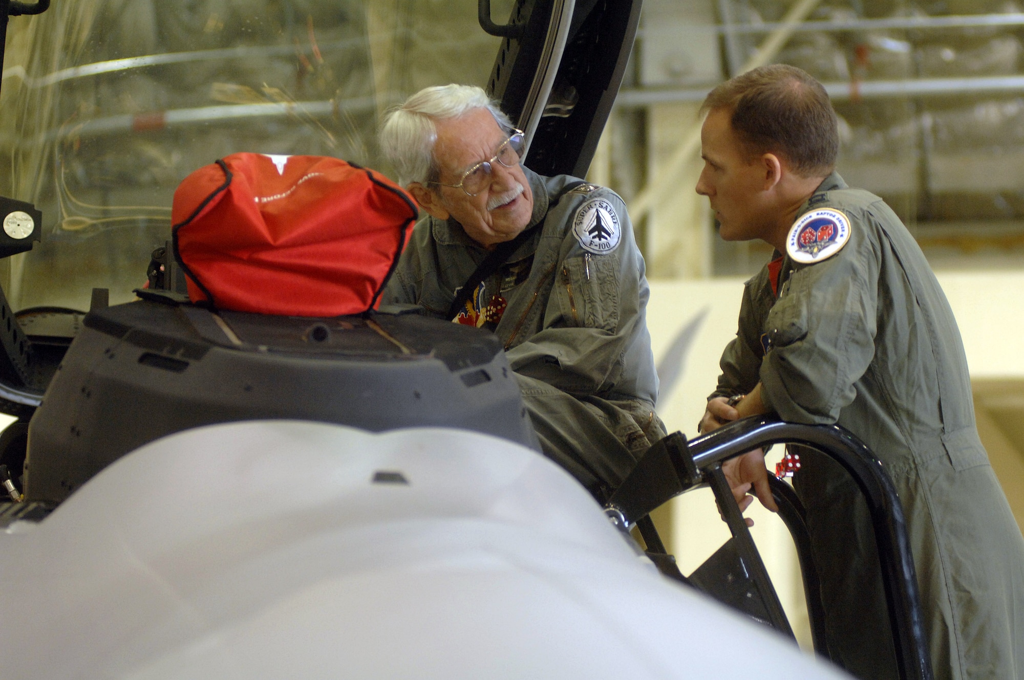 Capt. Brad Spears talks to retired Lt. Col. Bill Haynes about the capabilities of the F-22A Raptor Aug. 17 at Elmendorf Air Force Base, Alaska. Former and current 90th FS members celebrated the squadron's 90th anniversary Aug. 17-20. Colonel Haynes was commander of the 90th FS during the Vietnam War and Captain Spears is currently assigned to 90th FS. (U.S. Air Force photo/Senior Airman De-Juan Haley)
