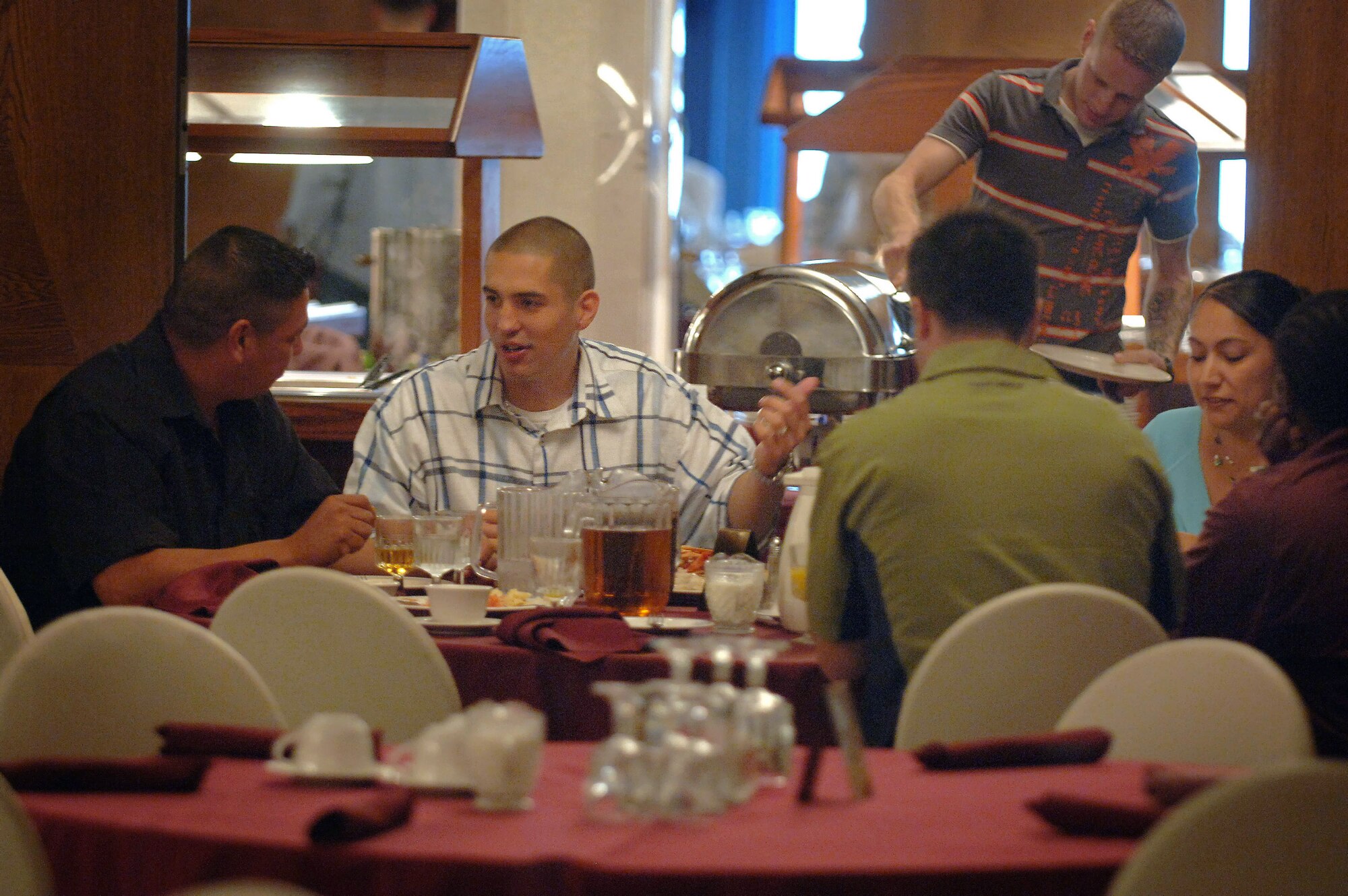 "Mission: Just Us" volunteers Master Sgt. Joel Shepherd (2nd from left) and his wife Erica (in blue)  join Landstuhl hospital outpatients for Sunday brunch at the Ramstein Air Base, Germany officers club. Volunteers in the chartered non-profit organization pay for the meals eaten by wounded servicemembers and provide free transportation for them to local eateries and the base exchange. (U.S. Air Force photo/Master Sgt. Scott Wagers)