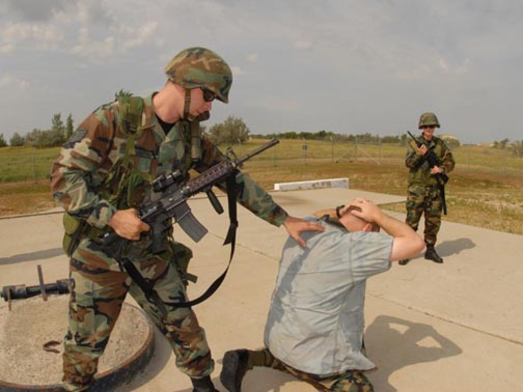 Staff Sgt. Martin L. Waller, 119th Security Forces Squadron, left, challenges simulated intruder, Capt. James Slaton, of the 91st Security Support Squadron, at a Minot Air Force Base missile field security forces training site as Senior Airman Jennifer M. Goulet, of the 119th Security Forces Squadron, provides over-watch support.  (USAF photo/SMSgt. David Lipp)
