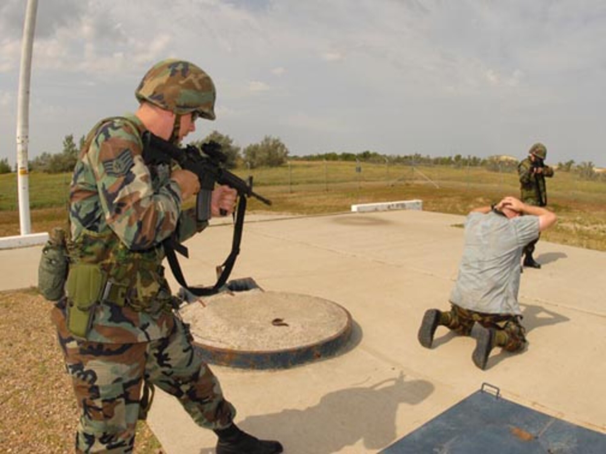 Staff Sgt. Martin L. Waller, 119th Security Forces Squadron, left, challenges simulated intruder, Capt. James Slaton, of the 91st Security Support Squadron, at a Minot Air Force Base missile field security forces training site as Senior Airman Jennifer M. Goulet, of the 119th Security Forces Squadron, provides over-watch support.  (USAF photo/SMSgt. David Lipp)
