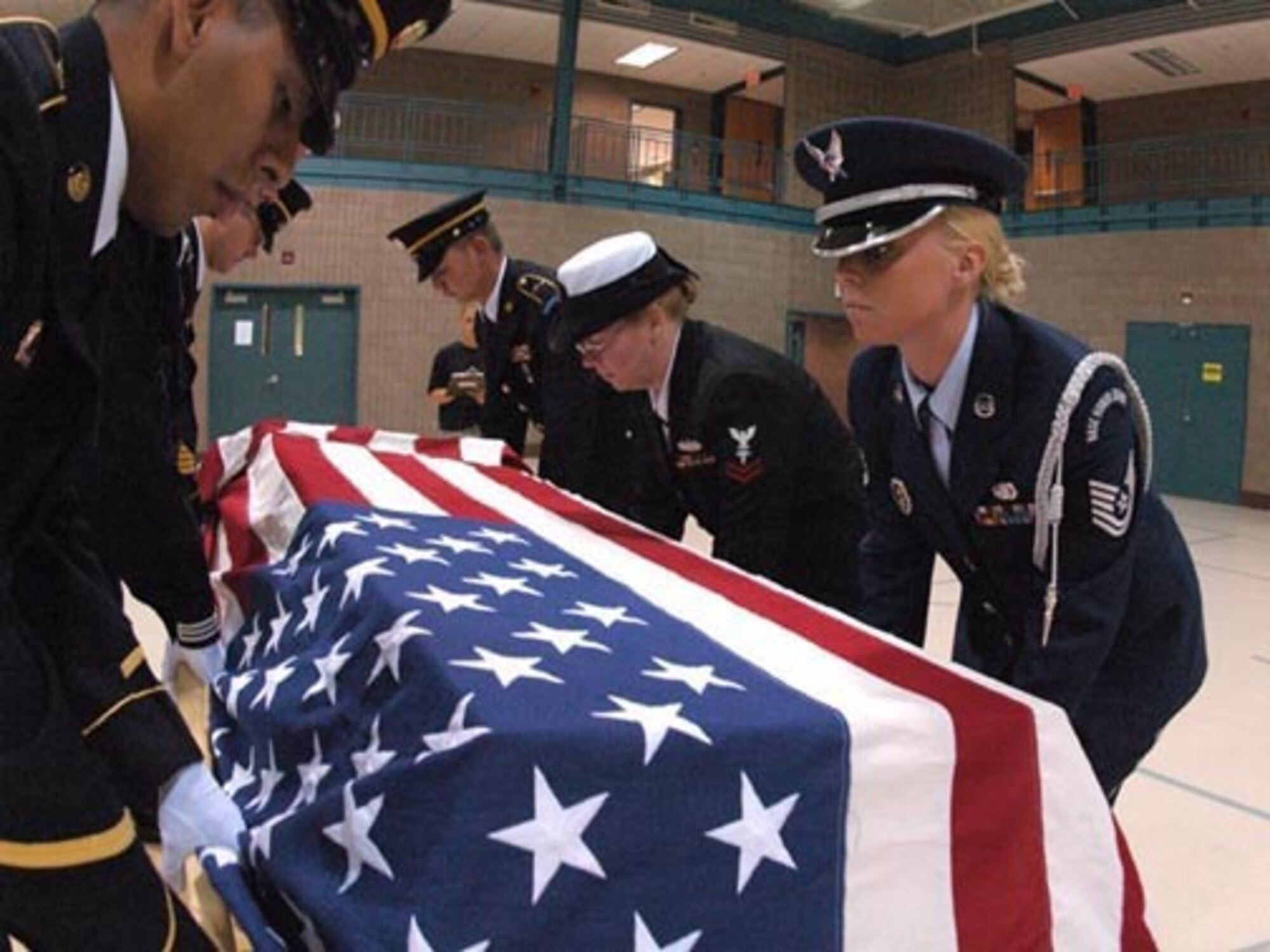 From right to left, Technical Sgt. Jolene R. Savageau, 119th Wing; Petty Officer 2nd Class Mary Sims; SPC Kacey Kruger; Staff Sgt. Travis Hackey; SPC Jorge Elizondo place a training casket during military funeral honor team training at the Armed Forces Reserve Center, Fargo, N.D., August 17, 2007.  (USAF photo/SMSgt. David Lipp)
