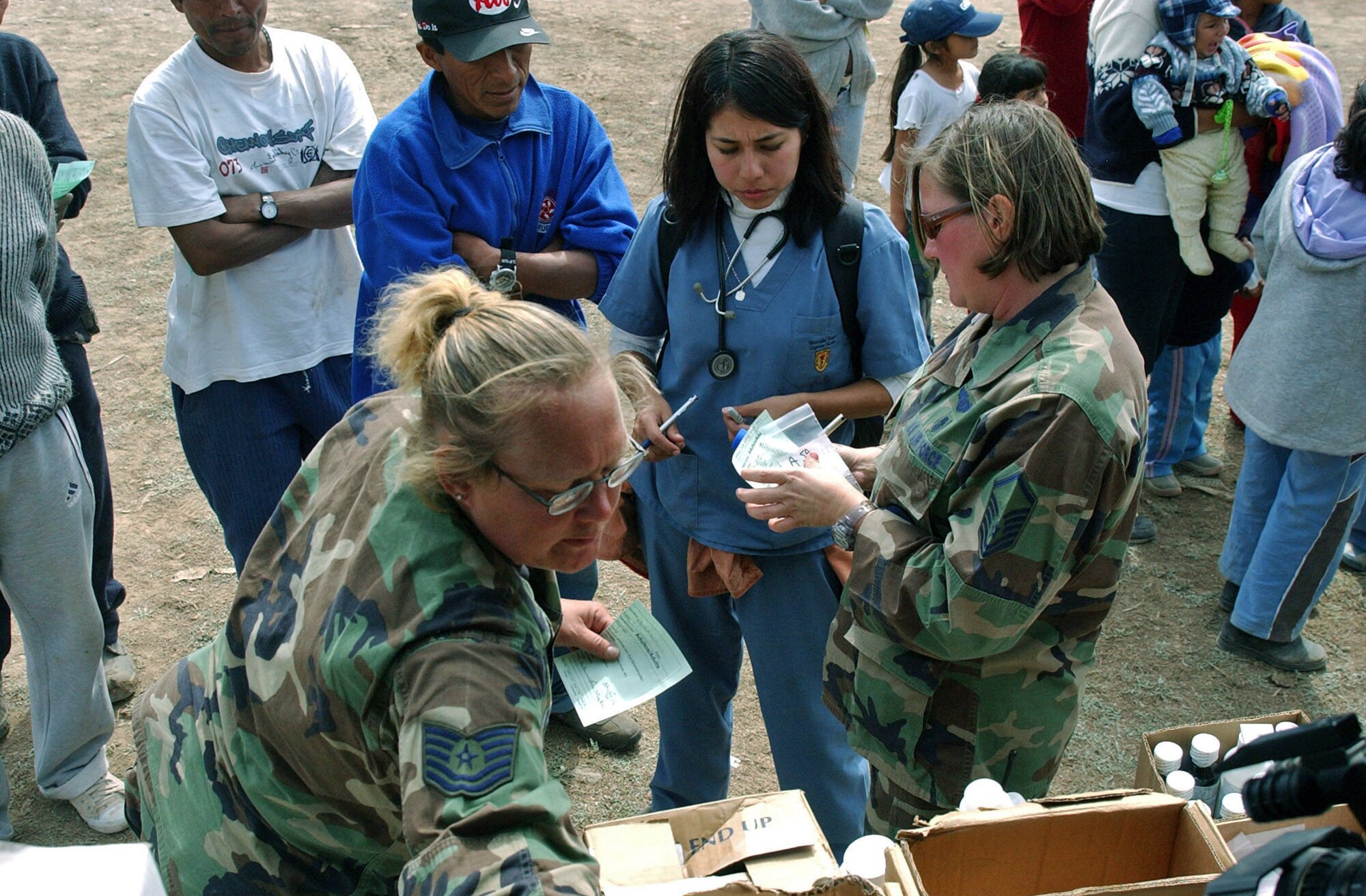 Tech. Sgt. Mellisa Walker (left) and Master Sgt. Deborah Davis distribute medicine to patients as part of the Joint Task Force-Bravo medical humanitarian mission Aug. 21 in Pisco, Peru. An 8.0 magnitude earthquake struck the region Aug. 15. The medical team was assisted by local paramedics who explained to patients when to take their medicine. (U.S. Air Force photo/Senior Airman Shaun Emery) 

