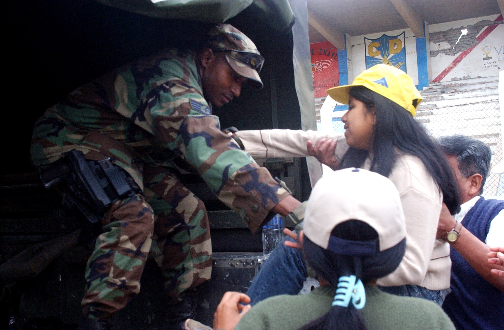 Staff Sgt. Glenn Gordon helps a Peruvian girl into the back of a Humvee for transport to the airport Aug. 21 in Pisco, Peru. An 8.0 magnitude earthquake struck the region Aug. 15. The medical team provided basic medical care to many of the citizens of Pisco at their field site. In the event a more serious diagnosis, the team was able to provide transportation for patients to facilities at the airport. Sergeant Gordon is a Joint Task Force Bravo joint security forces member. (U.S. Air Force photo/Senior Airman Shaun Emery) 
