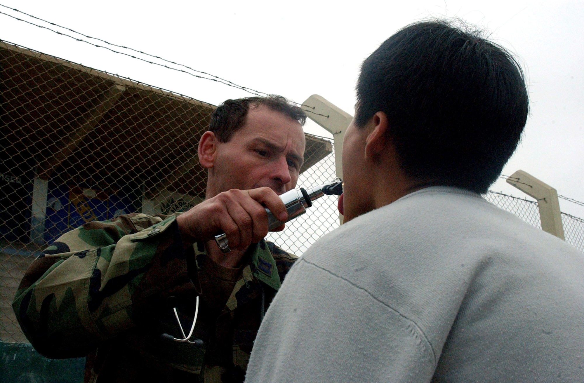 Capt. William Ingram checks the throat of a Peruvian boy complaining of a sore throat and cough Aug. 21 in Pisco, Peru. Captain Ingram is a physician's assistant for Joint Task Force-Bravo's medical element. The humanitarian relief task force was sent to Pisco following the 8.0 magnitude earthquake that struck the region Aug. 15. (U.S. Air Force photo/Senior Airman Shaun Emery) 
