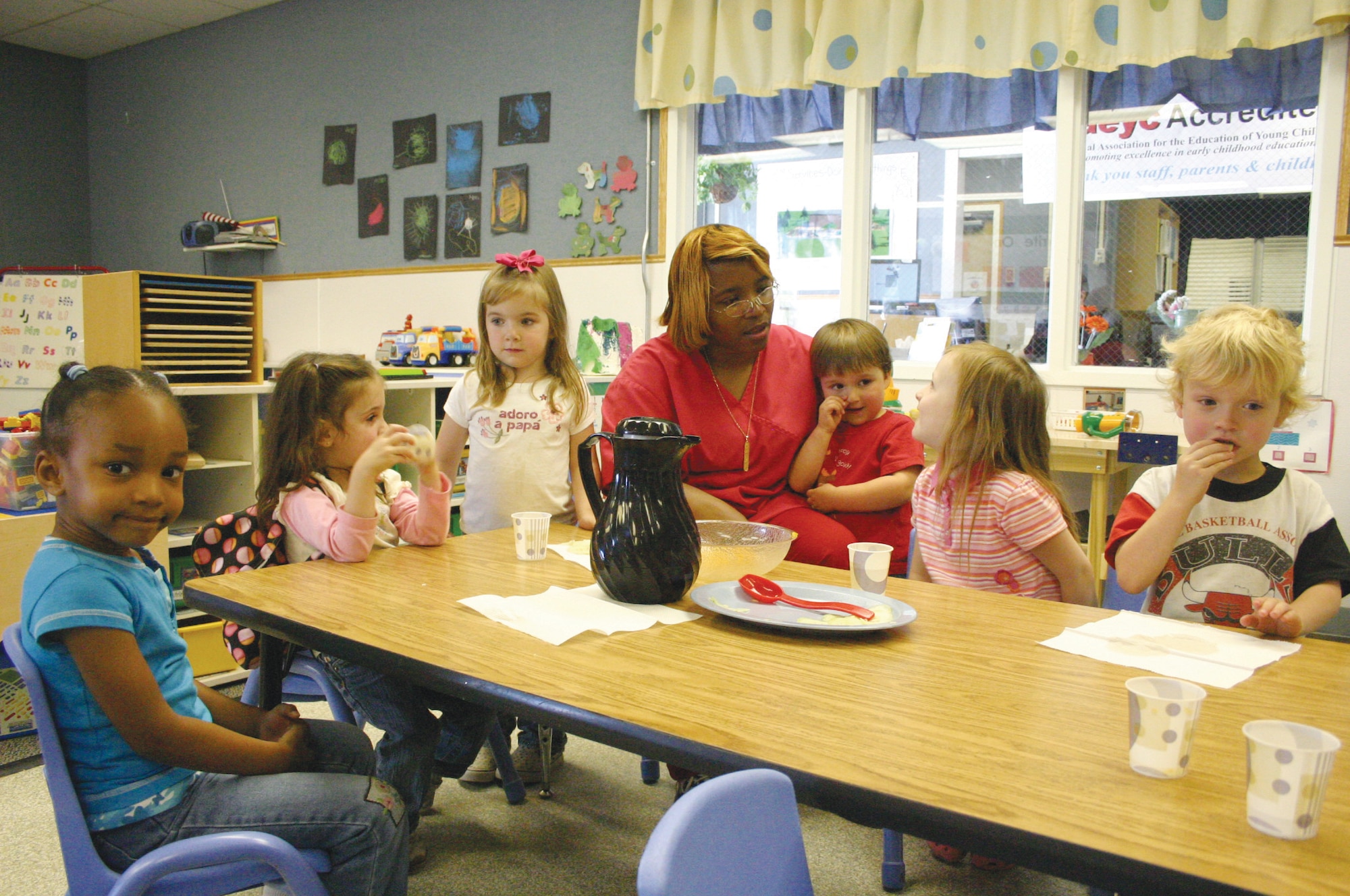Part Day Pre-school provider Catherine Smith talks with Jaylin Simmons, Emma Elder, Reign Aldridge, Jake Fleishaver, Allyson Reedy and Thomas Atchison about what they like to eat with their cucumbers.
To earn NAEYC accreditation, Katmai went through an extensive self-study process, measuring the program and its services against the ten new NAEYC Early Childhood Program Standards and more than 400 related accreditation criteria. (U.S. Air Force photo by Olenda Peña Perez)