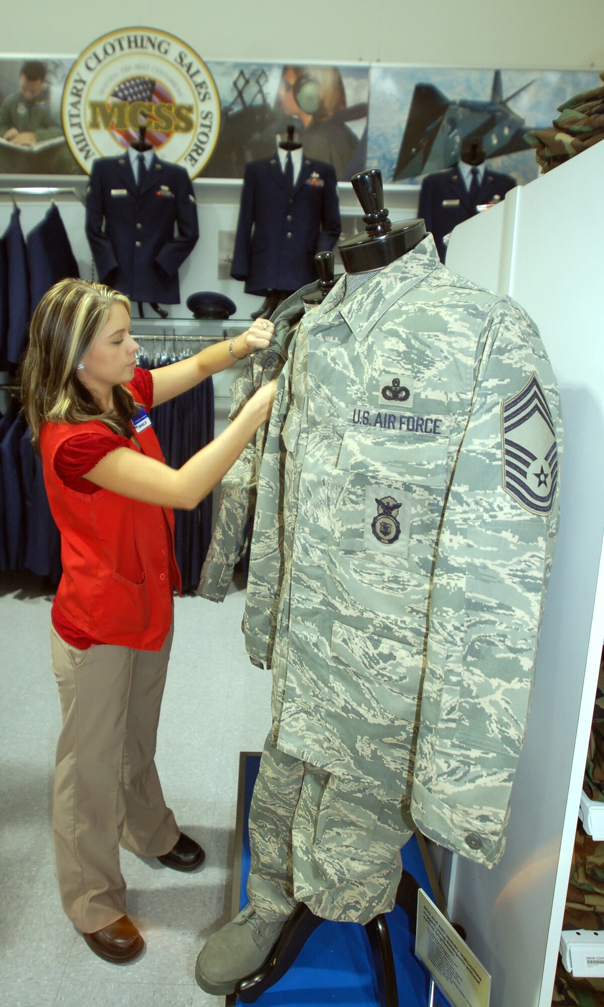Lisa Morgridge, Military Clothing Store senior store associate, fixes the Airman Battle Uniform display at the Base Exchange here Wednesday. The mandatory wear date for the new uniform is October 2011. (Photo by Airman 1st Class Julius Delos Reyes)
