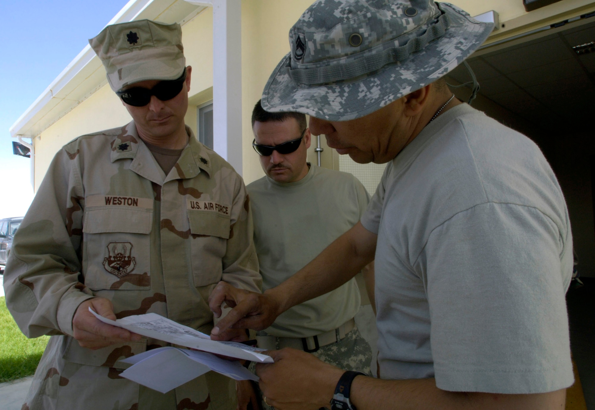 Lt. Col. Gil Weston (from left), Master Sgt. Doug Suddueth and Army Sgt. 1st Class Antonio Rivas look over a hospital schematic Aug. 18 in Afghanistan. The three are assisting in the installation of medical equipment into a new $6.5 million, 50-bed hospital on the Afghan national army Hero Camp near Kandahar Airfield in southern Afghanistan. Colonel Weston is a medical health facilities planner deployed from Atlanta. Sergeant Suddueth is deployed from Maxwell Air Force Base, Ala. Sergeant Rivas is deployed form Fort Sam Houston, Texas. They are medical logistics technicians and Afghan national army mentors assigned to the Combined Security Transition Command-Afghanistan on Camp Eggers in Kabul, Afghanistan. (U.S. Air Force photo/Master Sgt. Jim Varhegyi) 