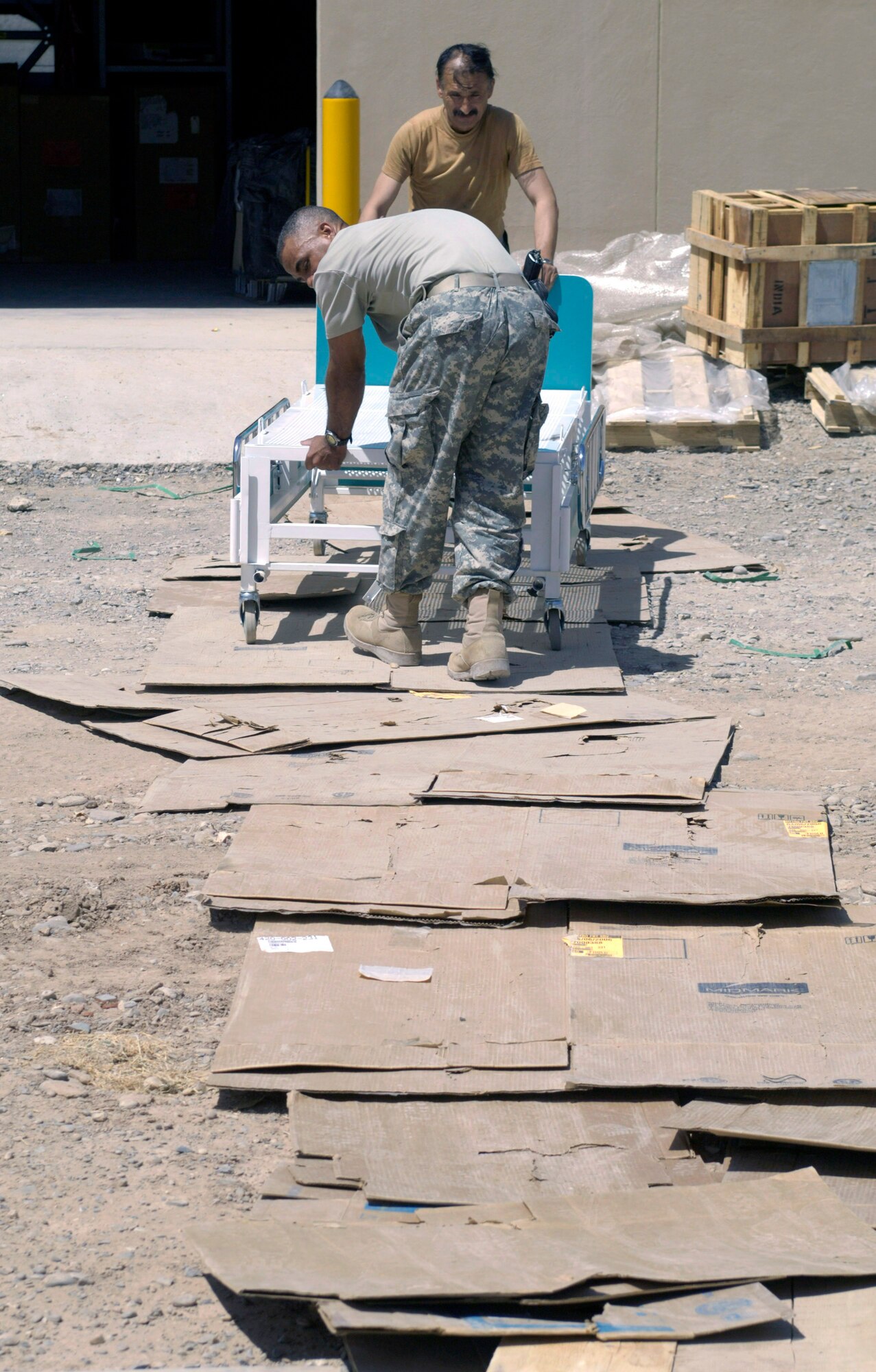 Afghan national army Maj. Abdul Ghafar (background) and Army Staff Sgt. Johnathan Moore wheel a hospital bed from a warehouse to a new $6.5 million, 50-bed ANA hospital Aug. 17 in Afghanistan. The state-of-the-art facility is located on the ANA's Hero Camp near Kandahar Airfield in southern Afghanistan. Major Ghafar is the ANA's 205th Hero Corps warehouse commander. He is also in charge of all logistical support for the 205th. Sergeant Moore is a medical logistics technician and ANA mentor deployed from Walter Reed Army Medical Center in Washington, D.C. He is assigned to the Combined Security Transition Command-Afghanistan on Camp Eggers in Kabul, Afghanistan. (U.S. Air Force photo/Master Sgt. Jim Varhegyi) 