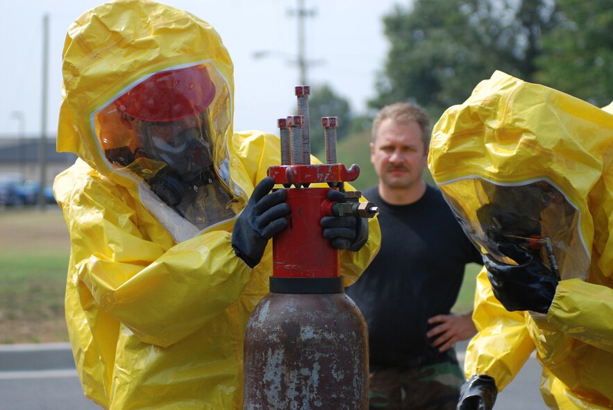 DOVER AIR FORCE BASE, Del. -- 512th Civil Engineer Squadron firefighters, Senior Airman Mike Gavaghan (left) and Staff Sgt. Francis Fajardo repair a valve leak on a simulated 150 pound corrosive cylinder as 512th CES firefighter, Tech Sgt. Todd Schoemeerlen, inspects their work.  Hazardous material handling training was held Aug. 17 here for both the 436th CES and the 512th CES. (U.S. Air Force photo/Staff Sgt. Steve Lewis)