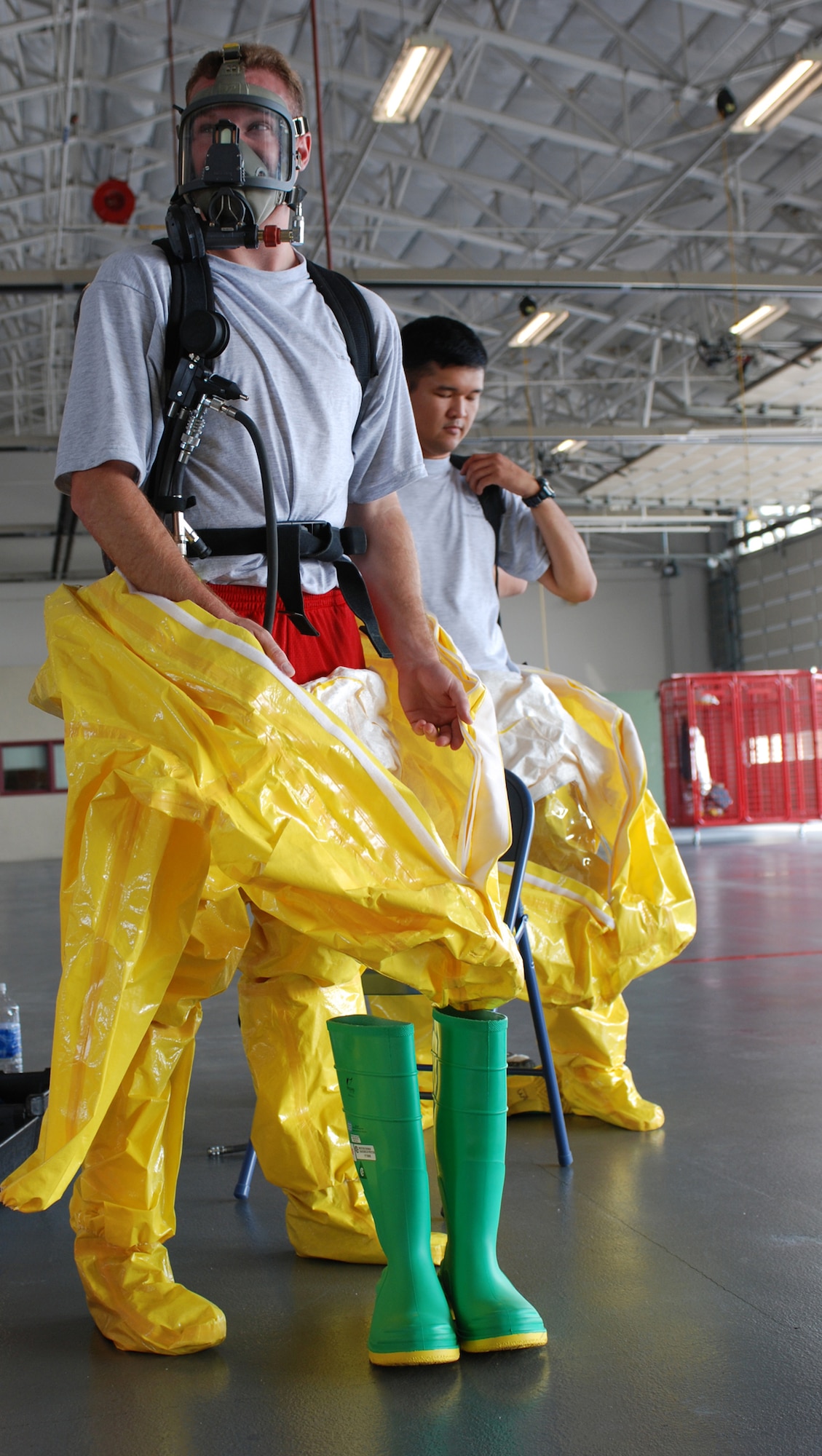 DOVER AIR FORCE BASE, Del. -- 512th Civil Engineer Squadron firefighters, Senior Airman Mike Gavaghan (left) and Staff Sgt. Francis Fajardo don protective gear as part of their training on handling hazardous material Aug. 17.  HAZMAT training was held here for both the 436th CES and the 512th CES outside of Building 140.  (U.S. Air Force photo/Staff Sgt. Steve Lewis)
