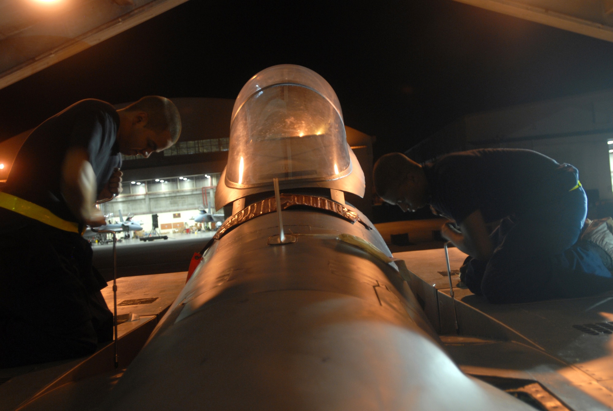 Airmen 1st Class Anthony Deleon (left) and Curtis Manley, use speed handles to place panels on an F-15C Eagle during a base exercise at Kadena Air Base, Japan, Aug. 23, 2007. By doing this they ensure that the panels are in place and won't fall off during flight.  The base conducted a three-day base exercise to demonstrate its ability to deploy and generate aircraft.   Both Airmen are phase crew chiefs with the 18th Equipment Maintenance Squadron. (U.S. Air Force Photo/Senior Airman Darnell T. Cannady)