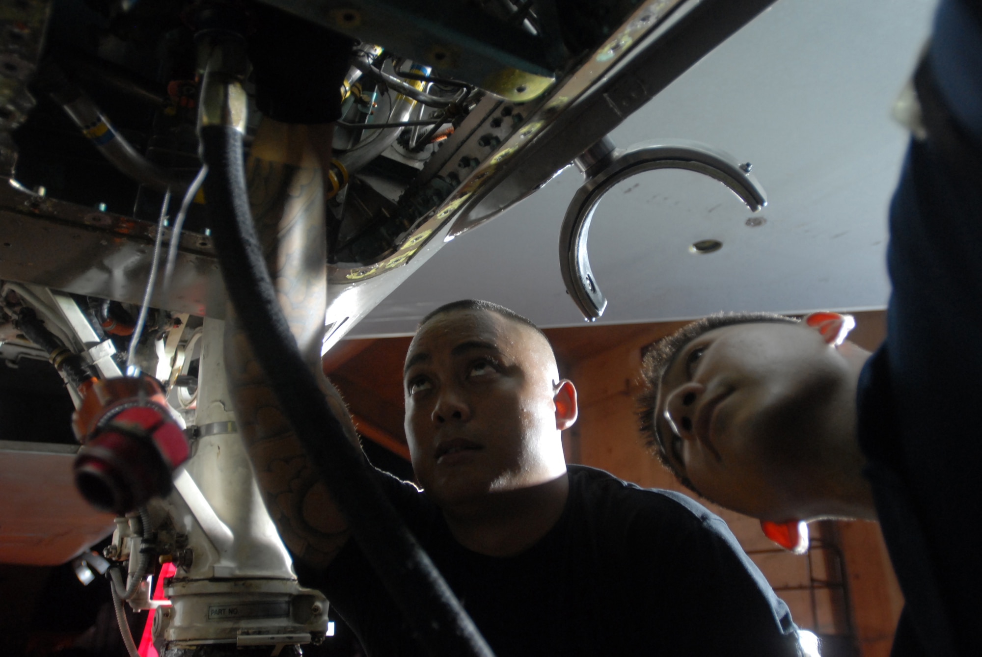 Airmen 1st Class Rico Babas (left) and Ernsto Mercado Jr. perform a reservoir service to an F-15C Eagle during a base exercise at Kadena Air Base, Japan, Aug. 23, 2007. The reservoir service is performed to fill the F-15 with hydraulic fluids. The base conducted a three-day base exercise to demonstrate its ability to deploy and generate aircraft.   Both Airmen are phase inspection team members with the 18th Equipment Maintenance Squadron. (U.S. Air Force Photo/Senior Airman Darnell T. Cannady)