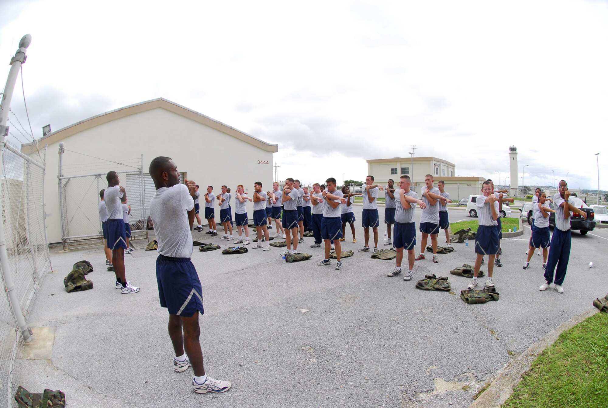 Airmen stretch prior to running during First Term Airmen Center physical training at Kadena Air Base, Japan, Aug. 22, 2007. FTAC does PT three days a week to meet the Air Force Fitness program requirment. FTAC is mandatory for all in-processing first-term Airmen which helps Airmen complete much of the in-processing paperwork.  (U.S. Air Force photo/Airman 1st Class Sheila deVera)