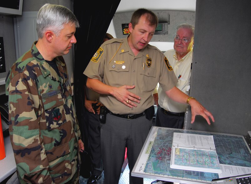 Brian Childress, patrol commander of the Valdosta Ga. Police Department, describes the features of the VPD’s new mobile command post to Col. Kenneth Todorov, 23rd Wing commander and Mr. Parker Greene, chairman of the Moody Support Committee, during a visit Aug. 24. to Moody Air Force Base. The command post includes extensive radio, cellular and satellite communications equipment, a breathalyzer machine and a holding cell for up to three people. The vehicle was at Moody to familiarize base emergency management and disaster response Airmen on its capabilities in the case of a joint emergency or mass-casualty disaster response. (U.S. Air Force photo by Tech. Sgt. Parker Gyokeres)