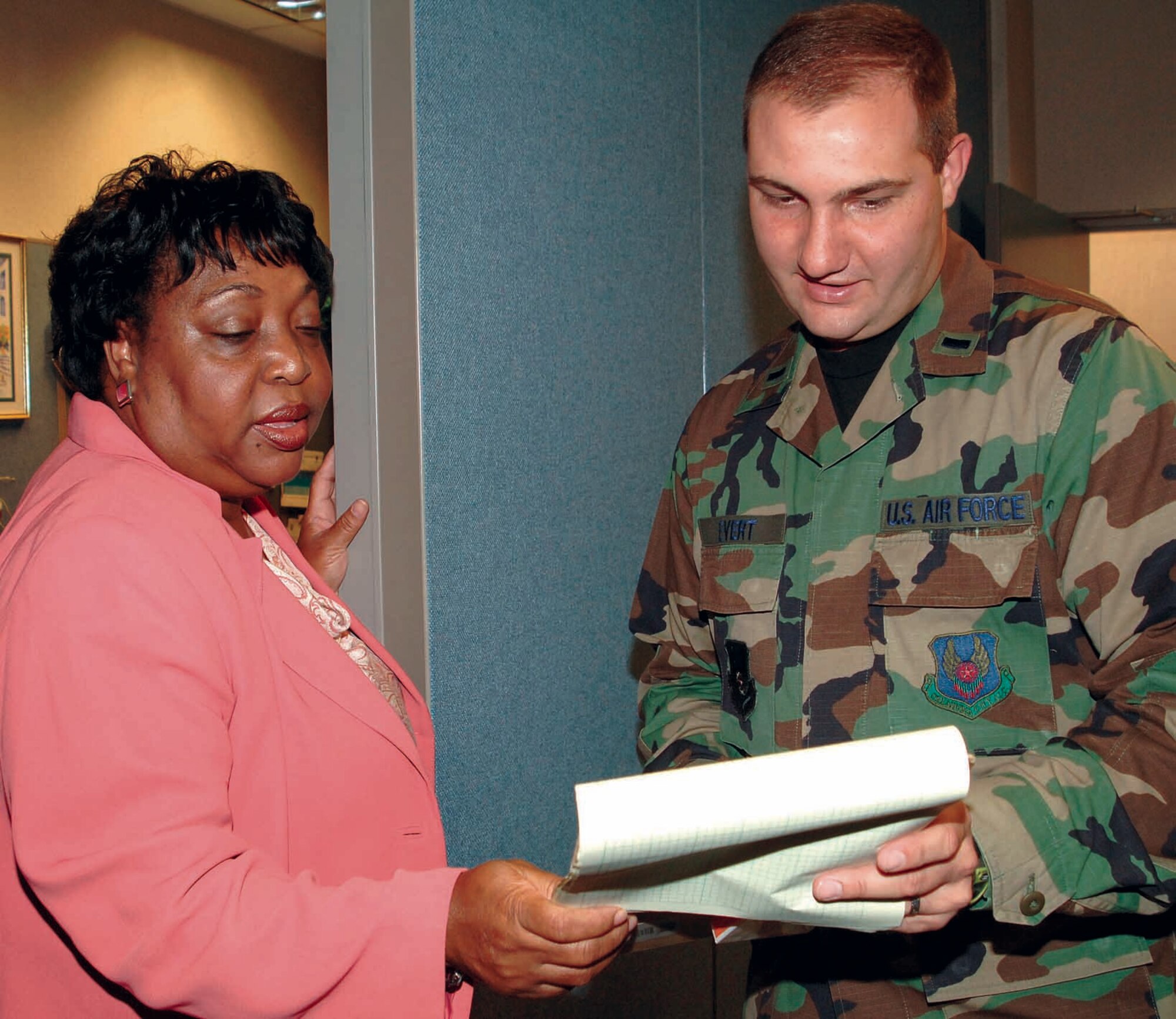 Georgia Washington, staff director, and 1st Lt. Jeremy Evert, system engineer, discuss an upcoming customer service visit to Pacific Air Force. (Air Force photo by Kelly Sharp)
