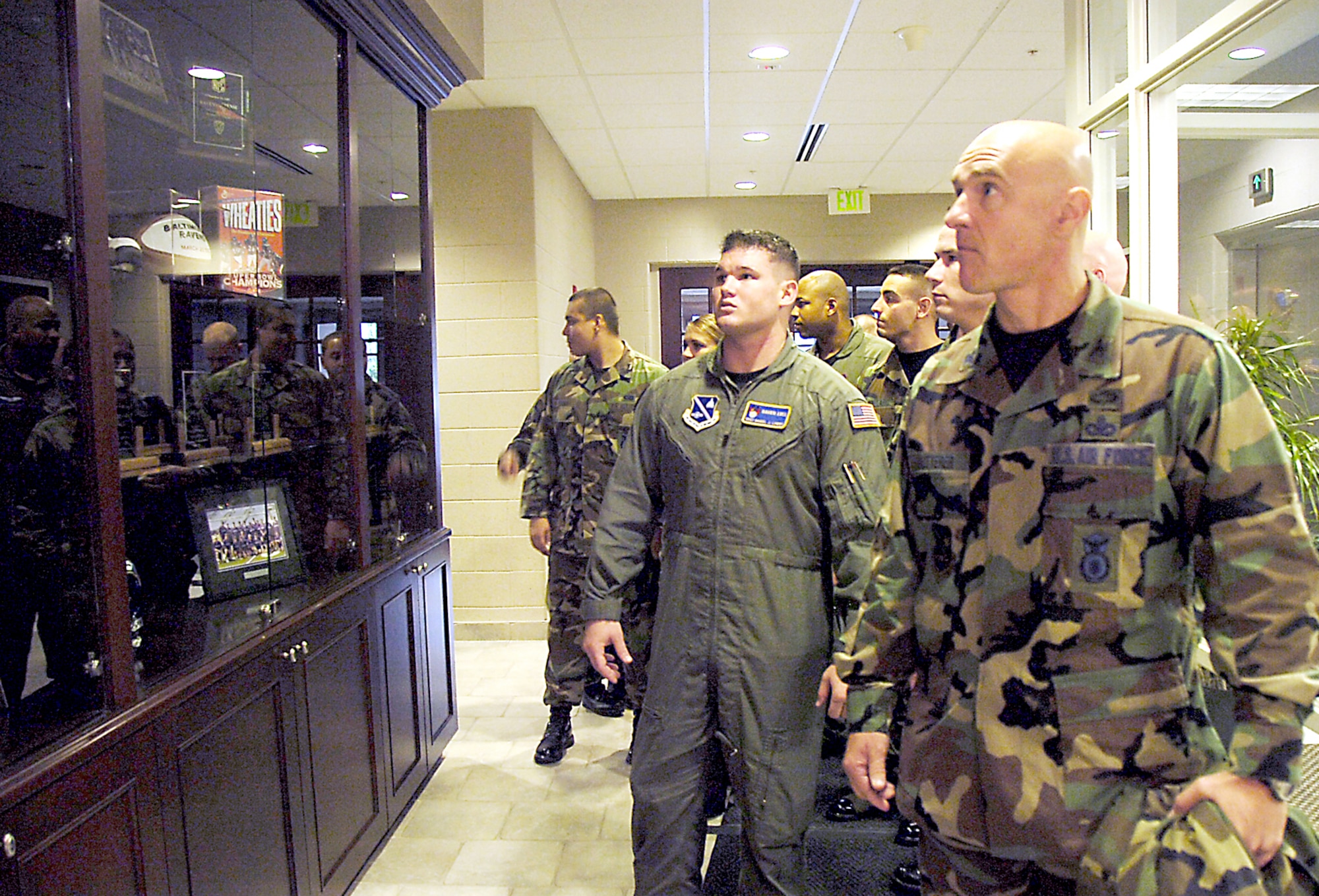Col. Robert Dutterer, 316 SFS deputy commander, is followed by several 316 Security Forces Squadron members as they look at a trophy case and team memorabilia on display, while touring the training camp facilities Tuesday. (U.S. Air Force/Bobby Jones)