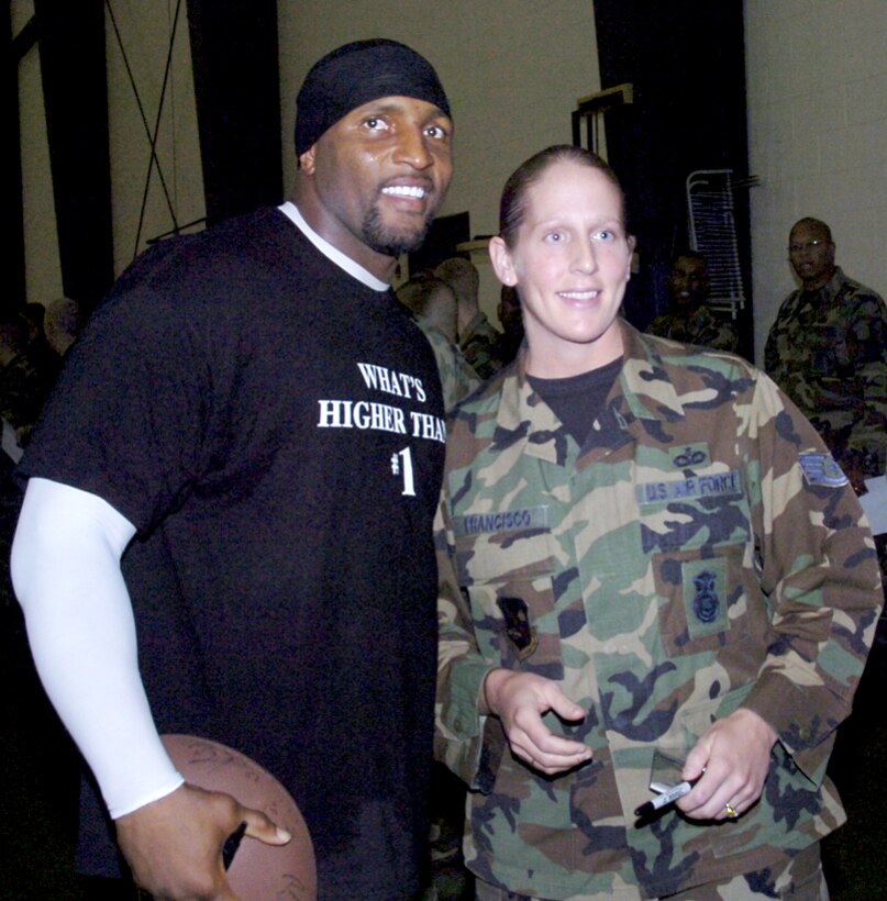 Ray Lewis takes time to autograph a football and pose for a  photograph with Staff Sgt. Leah Francisco. Sergeant Francisco is assigned  as the 316 SFS commander's executive. (U.S. Air Force/Bobby Jones)