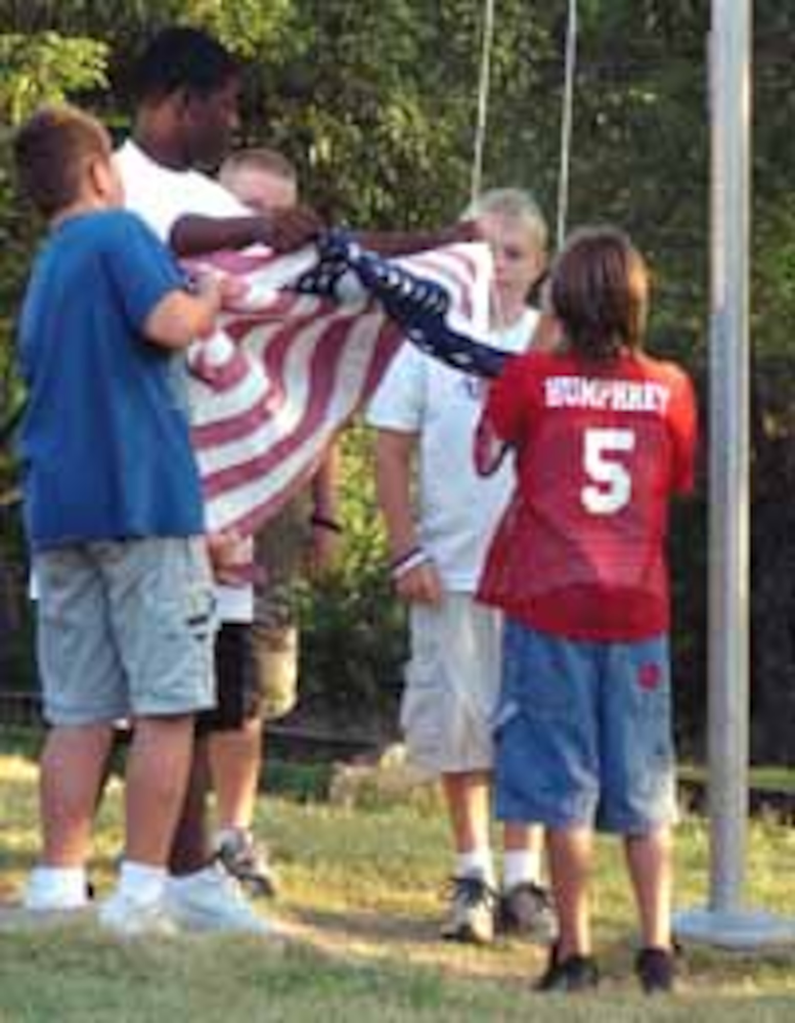 From left, Alan Van Bruggen, counselor Andie Hart, Forest Lasiter, Michael Davis and Dillan Rackley prepare to raise the flag over Camp Classen. (Photos courtesy of Tinker Youth Center)