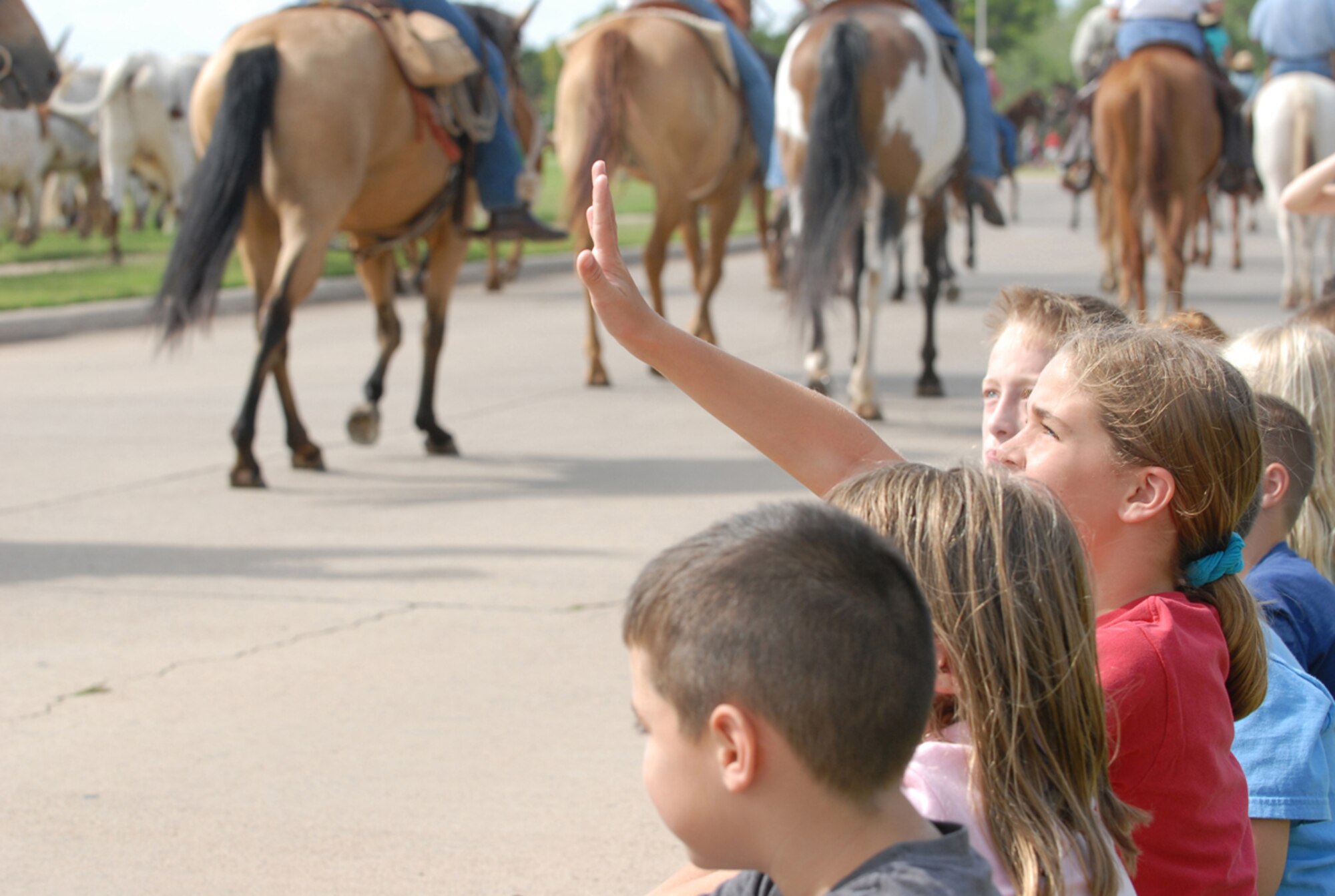 Children gaze as horses and longhorn steer walk through Altus Air Force Base,Okla., during the annual base cattle drive, Aug. 23, 2007. (U.S. Air Force photo/Airman 1st Class Cherice Bryant)