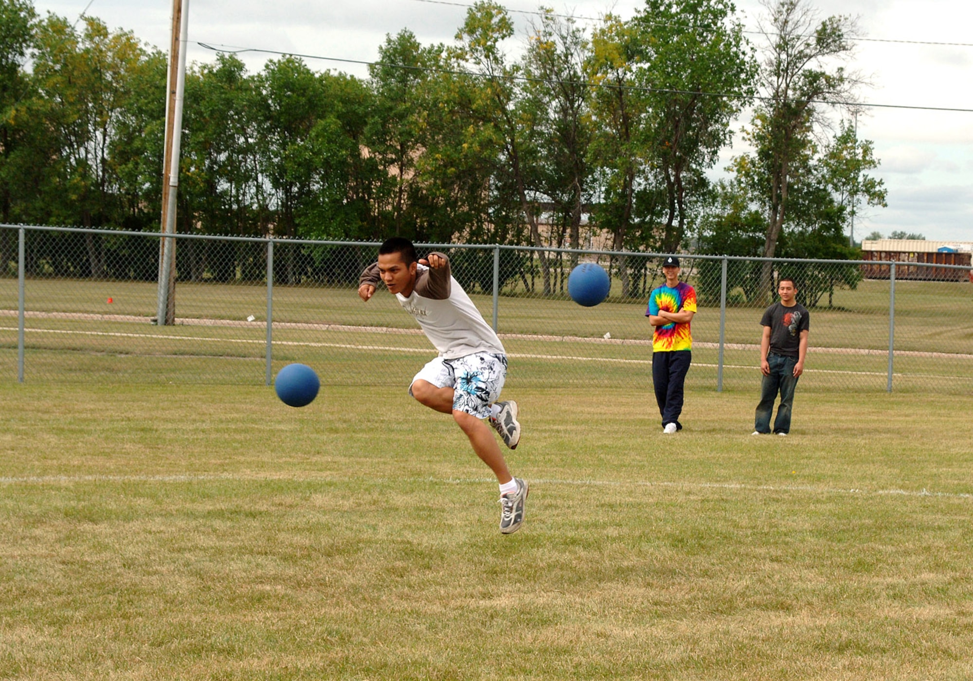 Airman 1st Class Rosseler Carreon, 319th Communications Squadron, takes the term "dodge ball" to heart, dodging two of the inflatable bombs. Dodge ball was one of many intra-squadron competitions during this year's Summer Bash. (U.S. Air Force photo/Senior Airman SerMae Lampkin)