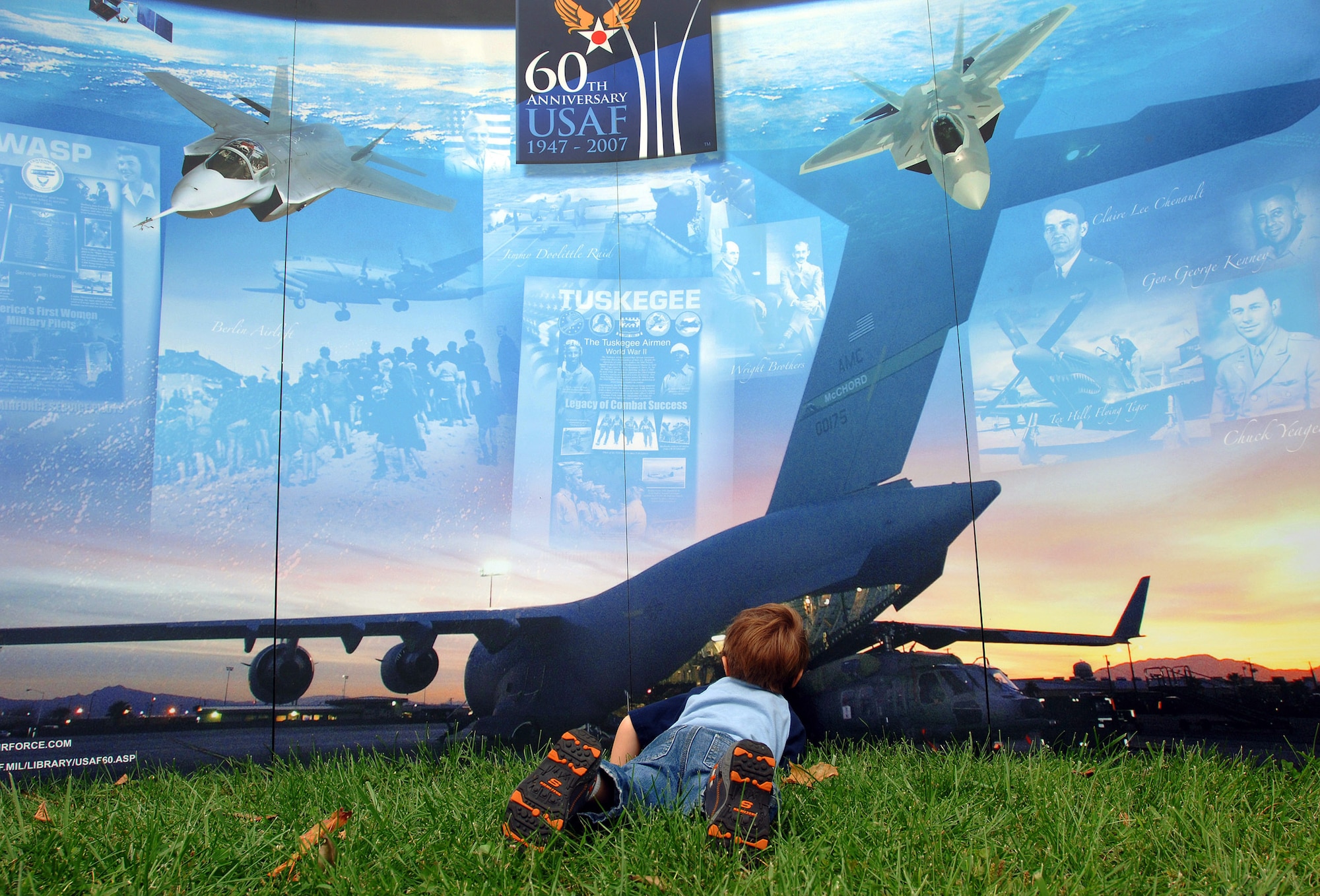 Four-year-old Kiaden from Concord, N.H., takes a closer look inside a 60th Anniversary Air Force display during Air Force New England Science Day Aug. 21 in Concord, N.H. "It looks like the big airplane is having a helicopter baby," said Kaiden of the picture of the C-17 Globemaster III unloading a Blackhawk helicopter. The Christa McAuliffe Planetarium hosted the Air Force New England Science Day, which provided children and adults hands-on displays of Air Force equipment, a model rocket launch demonstration, an F-16 Fighting Falcon static display, and "Do Something Amazing" display trailers. (U.S. Air Force photo/Staff Sgt. Bennie J. Davis III) 