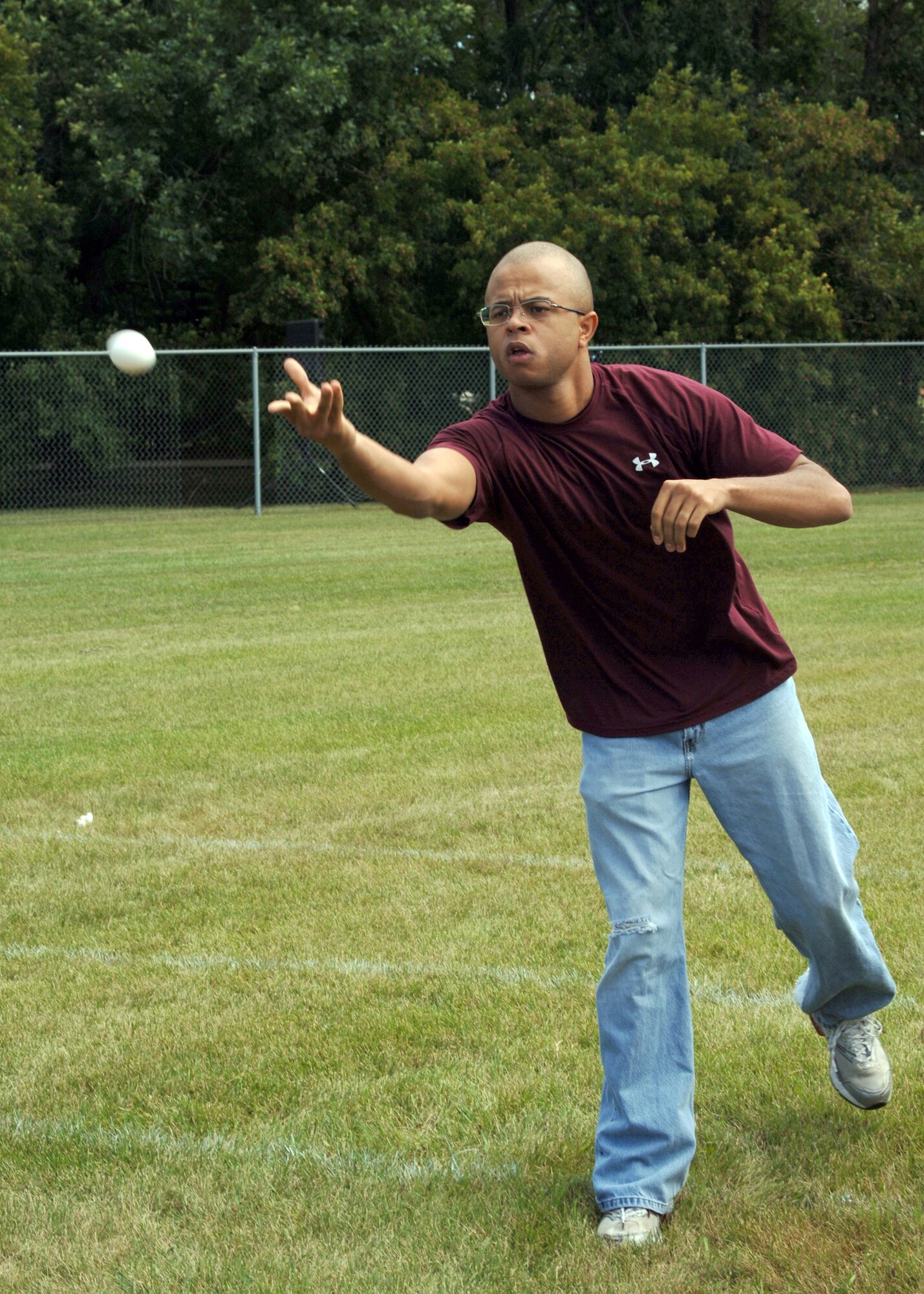 Staff Sgt. Marcus Young, 319th Civil Engineering Squadron, lobs an egg while competing in the egg toss competition during Summer Bash. In the end, the 319 CES team took the egg toss title. (USAF Photo By/Staff Sgt Suellyn Nuckolls)