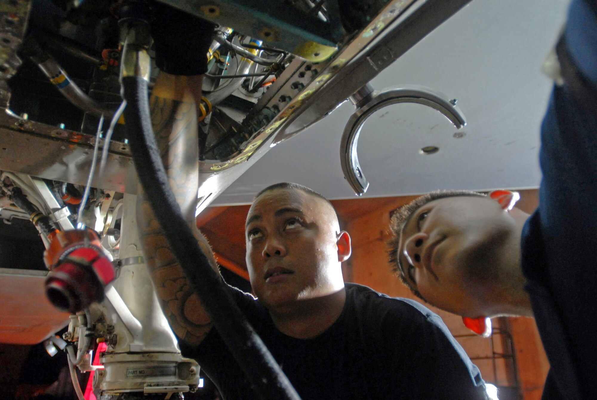 Airmen 1st Class Rico Babas (left) and Ernsto Mercado Jr. perform a reservoir service to an F-15 Eagle during an Aug. 23 base exercise at Kadena Air Base, Japan. The reservoir service is performed to fill the F-15 with hydraulic fluids. The base conducted a three-day base exercise to demonstrate its ability to deploy and generate aircraft. Both Airmen are phase inspection team members with the 18th Equipment Maintenance Squadron. (U.S. Air Force photo/Senior Airman Darnell T. Cannady)