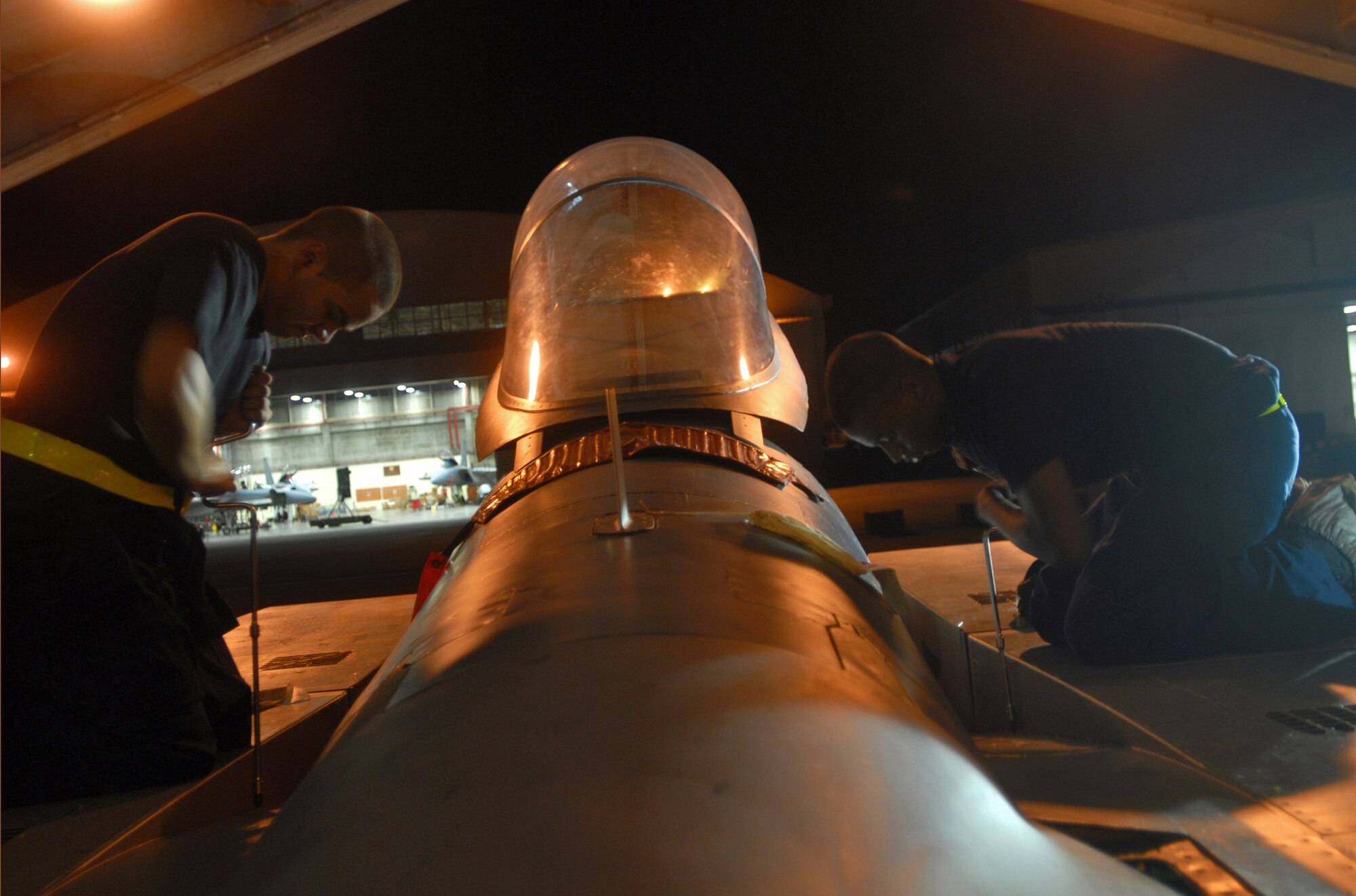 Airmen 1st Class Anthony Deleon (left) and Curtis Manley use speed handles to place panels on an F-15 Eagle during an Aug. 23 base exercise at Kadena Air Base, Japan. By doing this they ensure the panels are in place and won't fall off during flight. The base conducted a three-day base exercise to demonstrate its ability to deploy and generate aircraft. Both Airmen are phase crew chiefs with the 18th Equipment Maintenance Squadron. (U.S. Air Force photo/Senior Airman Darnell T. Cannady) 
