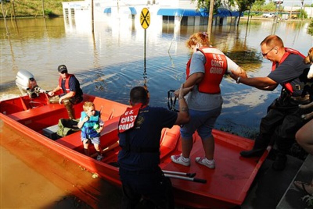 U.S. Coast Guardsmen assigned to disaster assistance response teams out of Louisville, Ky., and Huntington, W.Va., assist flood victims leaving their homes in Findlay, Ohio, on Aug. 23, 2007.  Coast Guard crews are working closely with state and local officials as more rain continues to threaten other parts of the state.  