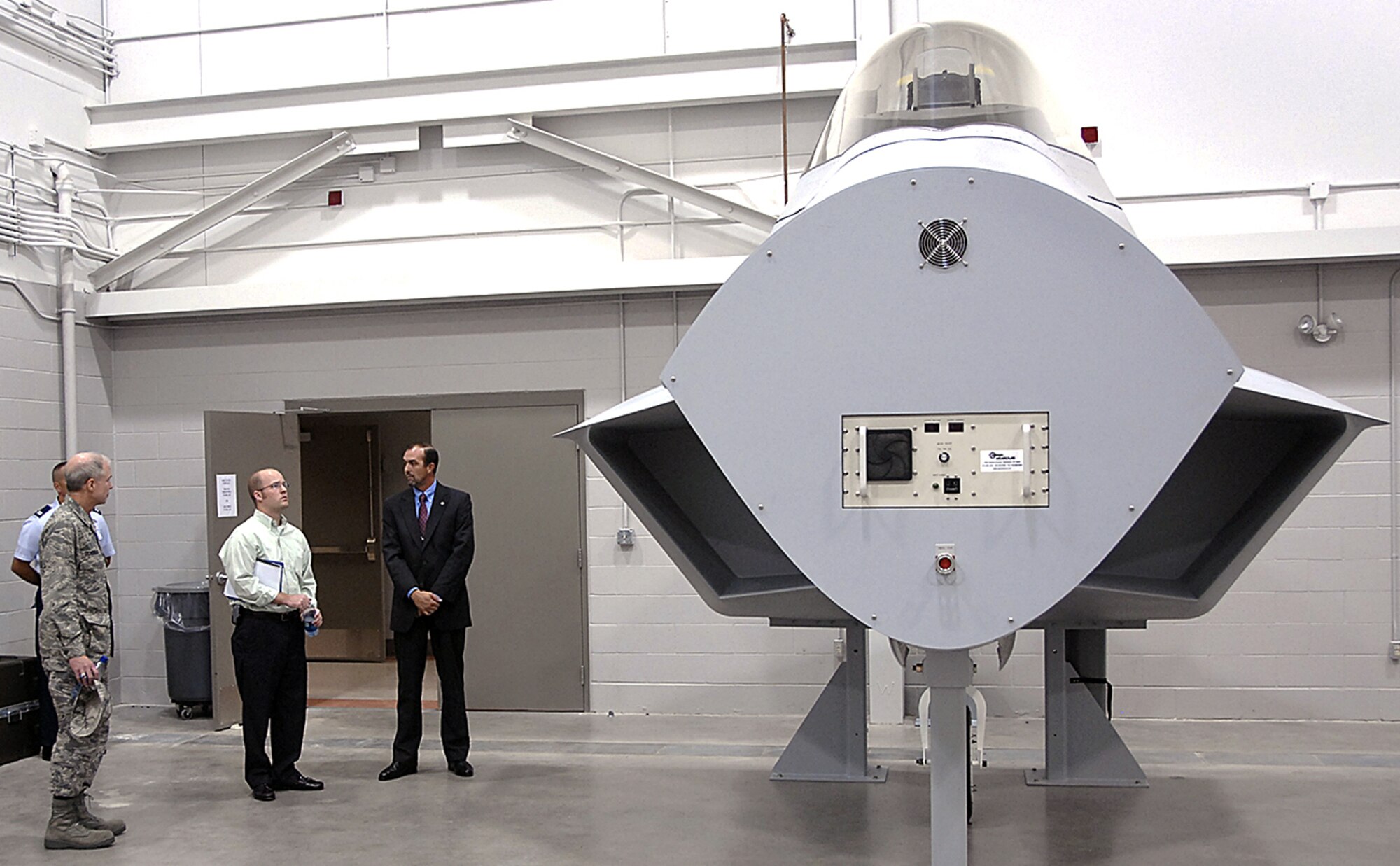 Ryan Crumpler, staffing aide to Congressman Mac Thornberry, R-Texas, checks out an F-22 mockup in Bldg. 1065 as part of his Sheppard orientation tour. From left: Brig. Gen. Richard Devereaux, 82nd Training Wing commander; Mr. Crumpler; and Donnie Manos, F-22 operations scheduler. (U.S. Air Force photo/Harry Tonemah)