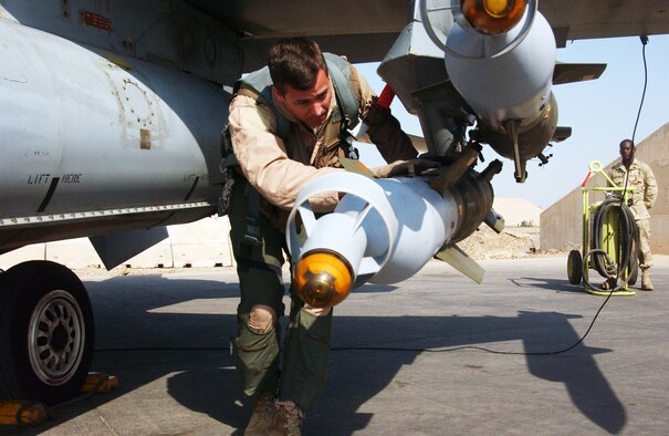BALAD AIR BASE, Iraq -- Col. Charles Moore inspects a GBU-12 on an F-16 Fighting Falcon Aug. 23 before climbing into the cockpit for a combat mission here while Airman 1st Class Jason Stevenson looks on. Colonel Moore is the 332nd Expeditionary Operations Group commander and Airman Stevenson is a weapons Airman with the 332nd Expeditionary Aircraft Maintenance Squadron. Colonel Moore and Airman Stevenson are both deployed here in support of Operation Iraqi Freedom from Misawa Air Base, Japan. (U.S. Air Force photo/Senior Airman Olufemi Owolabi) 