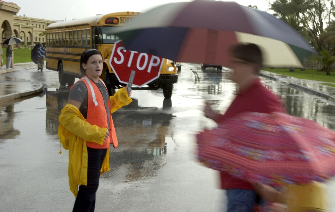 ANDERSEN AIR FORCE BASE, Guam - Savannah Malphrus, a fifth-grader, holds traffic for a mother and daughter as they cross Plumeria Boulevard on their way to Andersen Elementary School.  Andersen Elementary and Middle Schools opened on Andersen Aug. 27 for the 2007-2008 school year.  (Photo by Tech. Sgt. Brian Bahret/36th Wing Public Affairs)