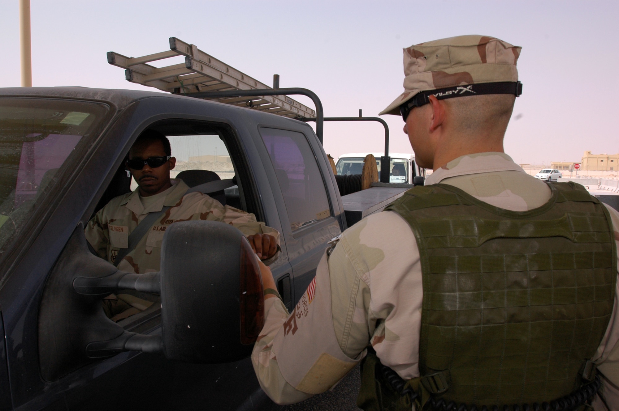 Airman 1st Class Nicholas Harrison, 379th Expeditionary Security Forces Squadron entry controller, checks IDs at an entry control point. Since arriving here, Airman Harrison has participated in a fly-away mission, which provides security for forward deployed aircraft. This is his first deployment. (U.S. Air Force photo by Senior Airman Clark Staehle)