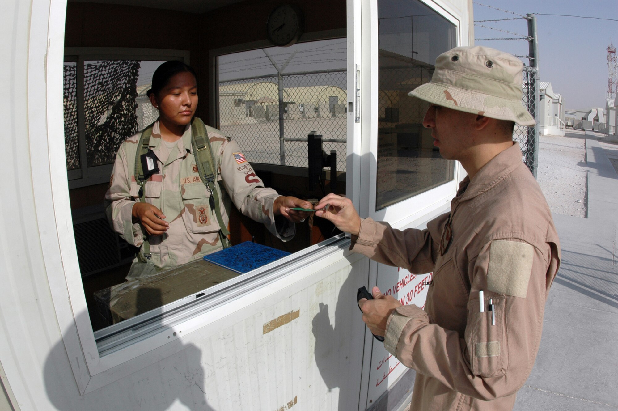 Staff Sgt. Shynowah Bahe, 379th Expeditionary Security Forces Squadron, assigns a visitor badge to an Airman. Sergeant Bahe is deployed here from Luke Air Force Base, Ariz. and is a native of Woodsprings, Ariz. (U.S. Air Force by Senior Airman Clark Staehle)