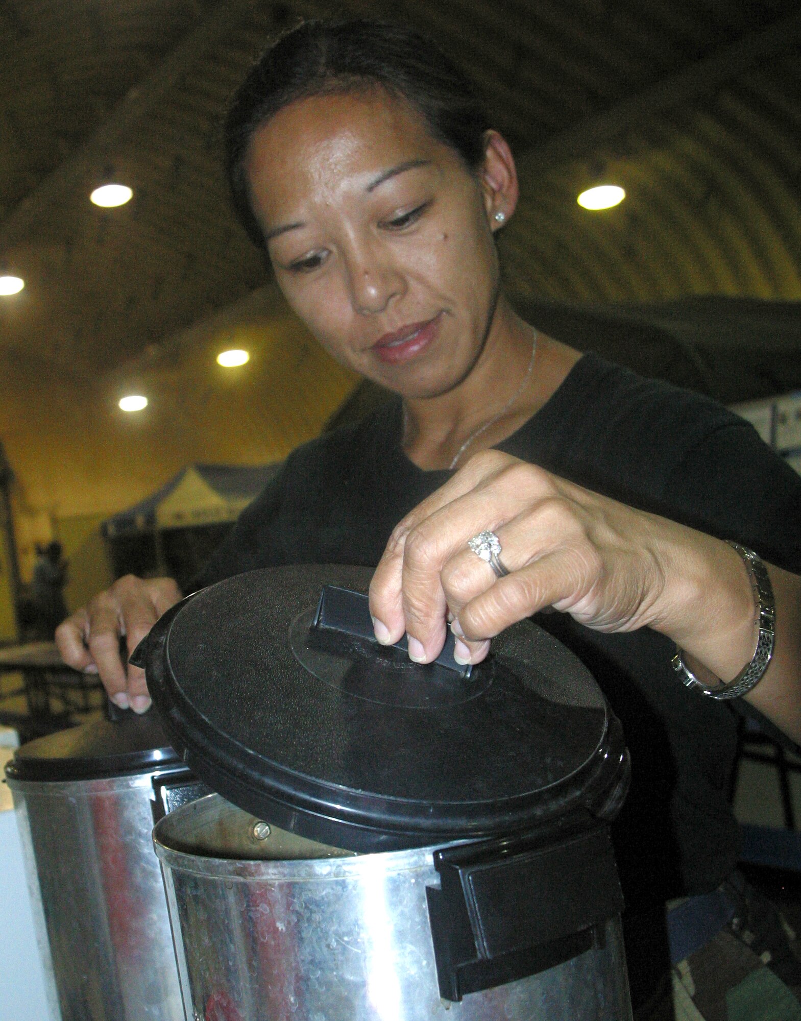 OSAN AIR BASE, South Korea -- Staff Sgt. Carmela Rapadas, 254th Service Flight, Guam Air National Guard, prepares coffee for Ulchi Focus Lens 2007 augmentees at the air base's tent city headquarters. The services flight Airmen, supporting UFL as augmentees themselves, are proud for the positive attitude they greet each augmentee with as they enter tent city for the first time, according to Sergeant Rapadas. She continued, pointing out how they offer weary servicemembers with smiles, quick service and fresh coffee to ease the last stage of improcessing. (U.S. Army photo/Spc. Bill Addison)