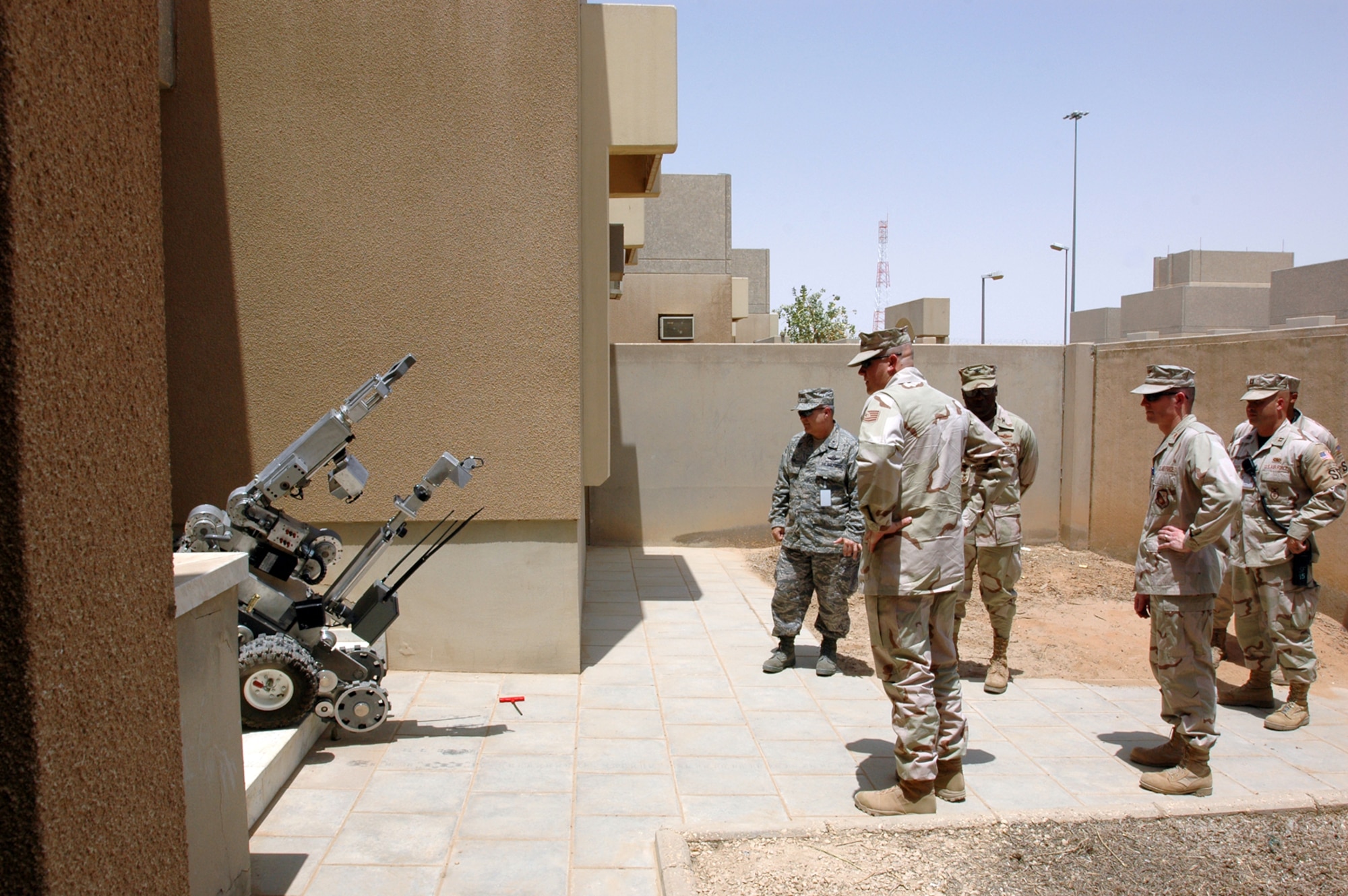 Brig. Ge. Charlie Lyon, 379th Air Expeditionary Wing commander (left), watches as an explosive ordnance disposal robot with the 64th Air Expeditionary Group prepares to enter a building to defuse a simulted improvised explosive device during a base exercise at a foward deployed location Aug. 20. (U.S. Air Force photo by Capt. Teresa Sullivan)