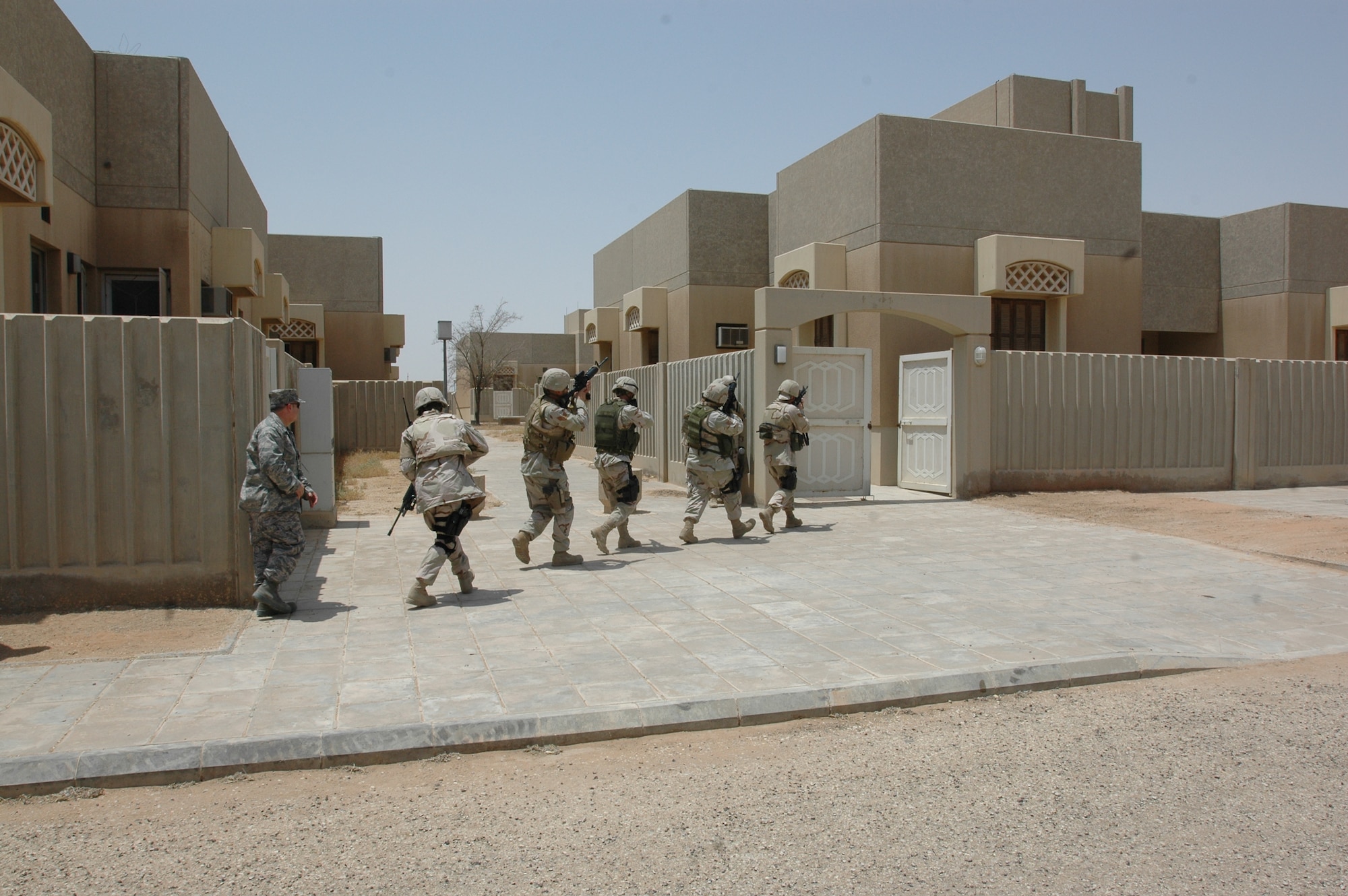 Brig. Gen. Charlie Lyon, 379th Air Expeditionary Wing commander (left), follows Airmen with the 64th Air Expeditionary Group as they storm a building during a base defense demonstration at a forward deployed location Aug. 20. (U.S. Air Force photo by Capt. Teresa Sullivan)