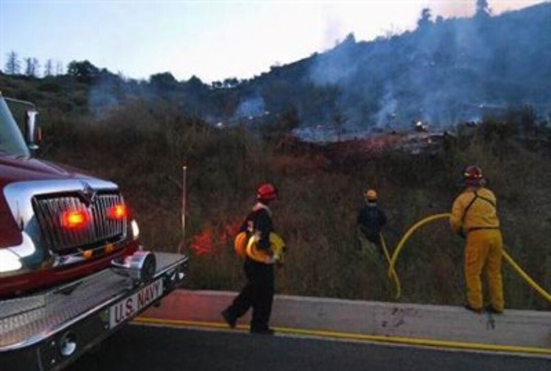 U.S. Navy firefighters assigned to U.S. Naval Support Activity Souda Bay help fight a brush fire near the mountain village of Lakki in western Crete, Greece,  Aug. 24, 2007. The fires have claimed at least 49 lives, according to news reports. 