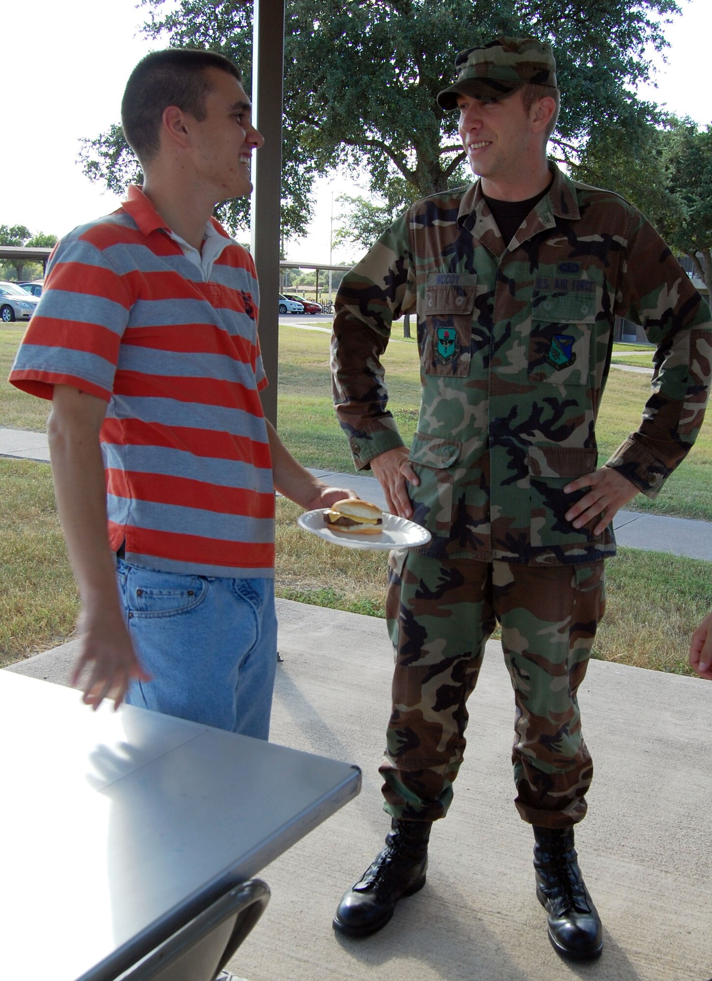 LAUGHLIN AIR FORCE BASE, Texas -- Airman 1st Class Joseph Sleeman, Laughlin Fire Department, and Airman 1st Class Scott McCoy, 47th Contracting Squadron, converse over cheeseburgers during the "Cookout Delux" August 24 hosted by Chaplain (Capt.) Shannon Workman and chapel community. (U.S. Air Force photo by Airman Sara Csurilla)