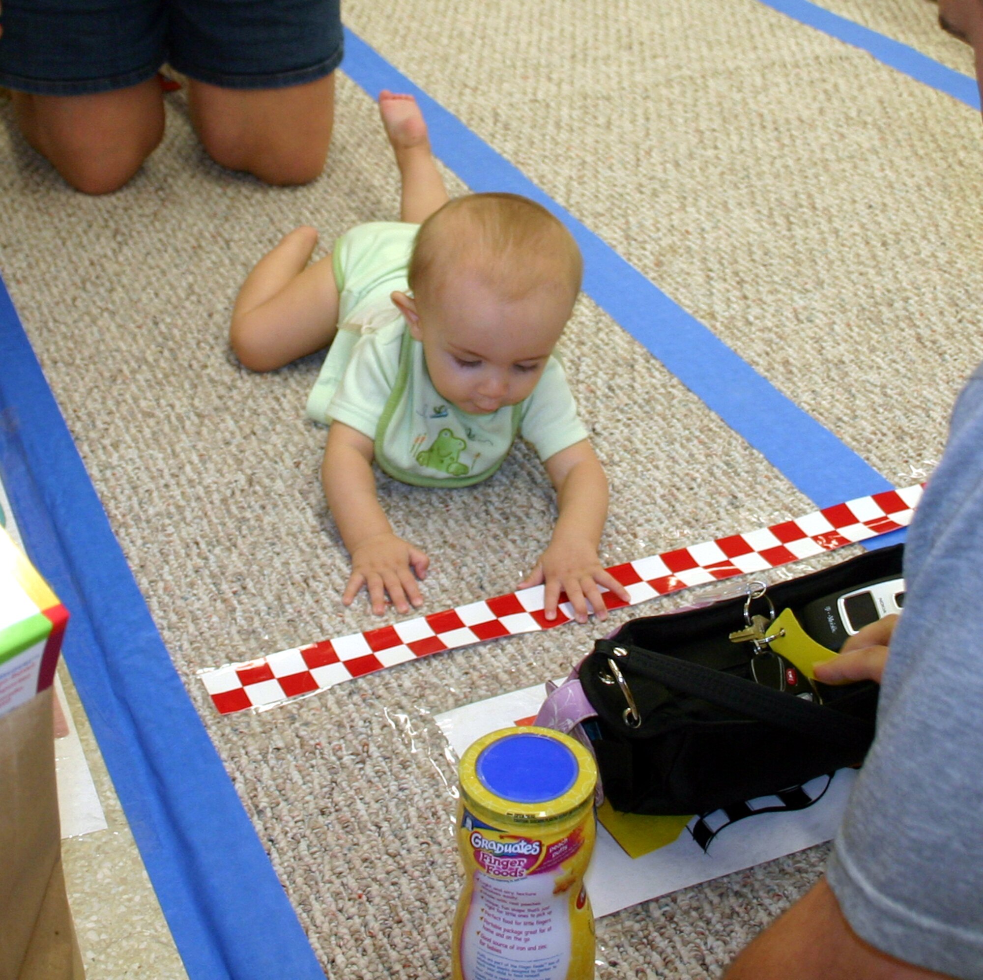 Scotty Brayerton, Jr. reaches for his mother's purse to cross the finish line at the Hotter'N Heck diaper derby Aug. 26.  Brayerton won first place in the 0-9 months category. (U.S. Air Force photo/Staff Sgt. Tonnette Thompson)