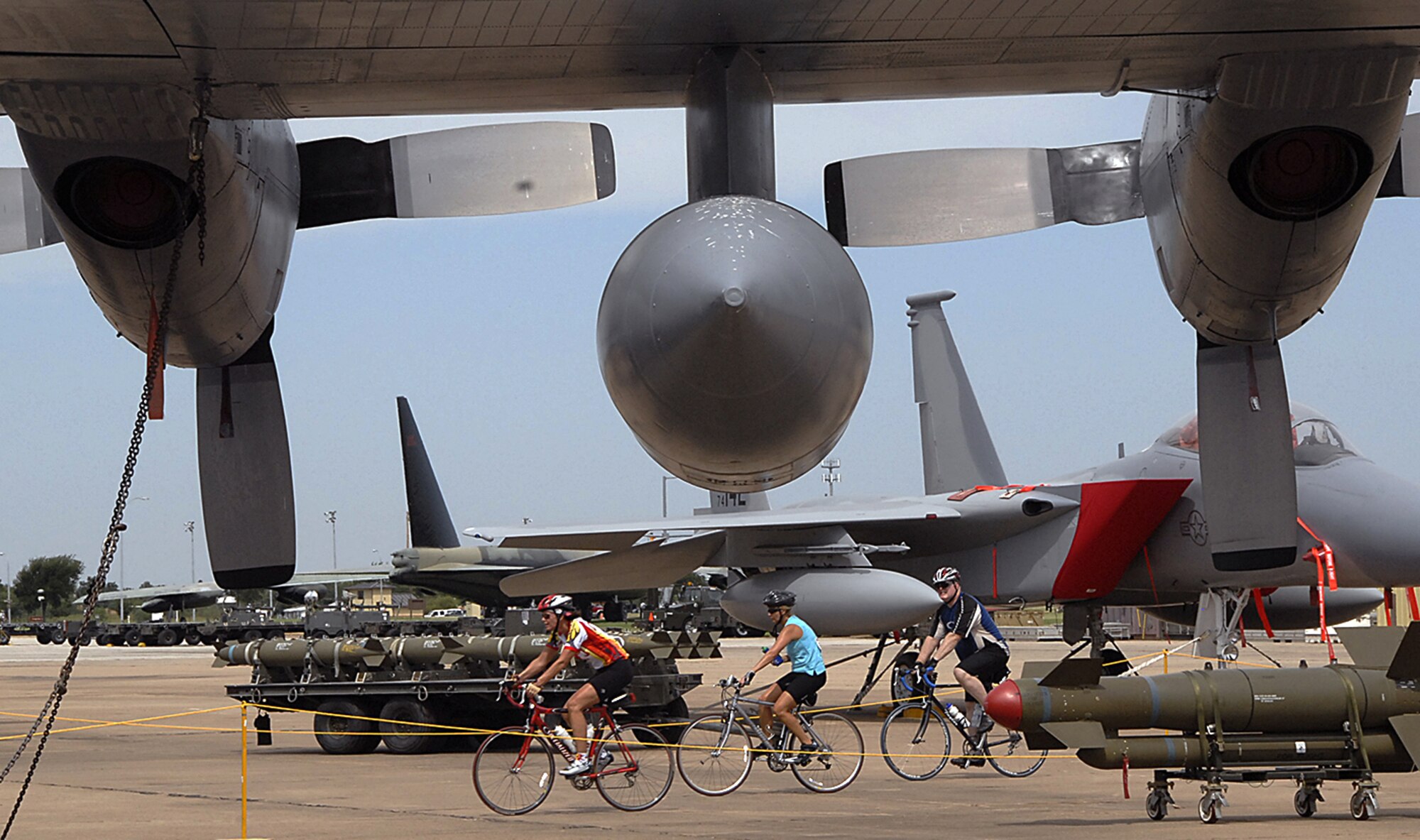 Bikers ride past a C-130 as their Hotter'N Hell route takes them through Sheppard Aug. 25.  Sheppard also featured a rest stop for the cyclists at the Pitsenbarger Fitness Center. (U.S. Air Force photo/Harry Tonemah)
