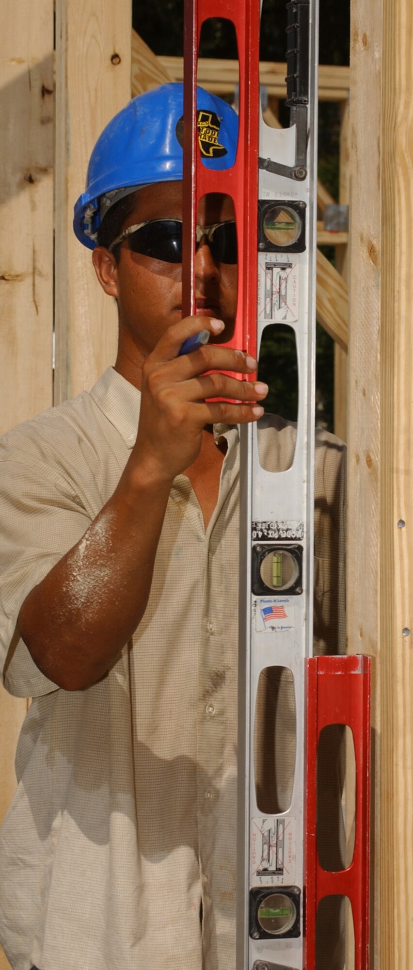 Diego Alvarez plumbs the interior walls in the first framed house in Thrower Park.  (U.S. Air Force photo by Kemberly Groue)