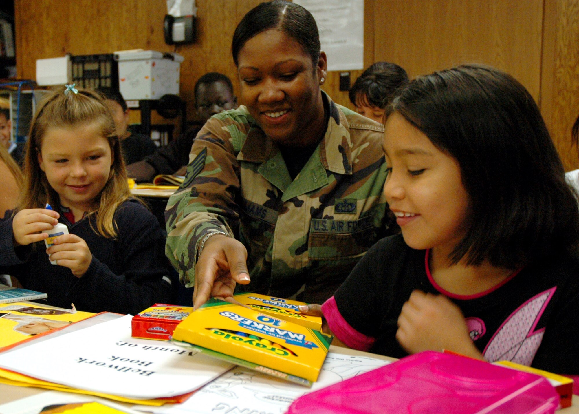 Staff Sgt. Kenyatta Williams helps 8-year-olds Devon Stafford (left) and Sandra Gijon with their new school supplies Aug. 23 at Indian Hill Elementary School in Omaha, Neb. An Air Force Weather Agency team collected 200 pounds of assorted school supplies and delivered them to the school's children. Sergeant Williams is the assistant NCO in charge of net-centric database management and data routing for AFWA's 2nd Systems Operations Squadron. (U.S. Air Force photo/G. A. Volb)
