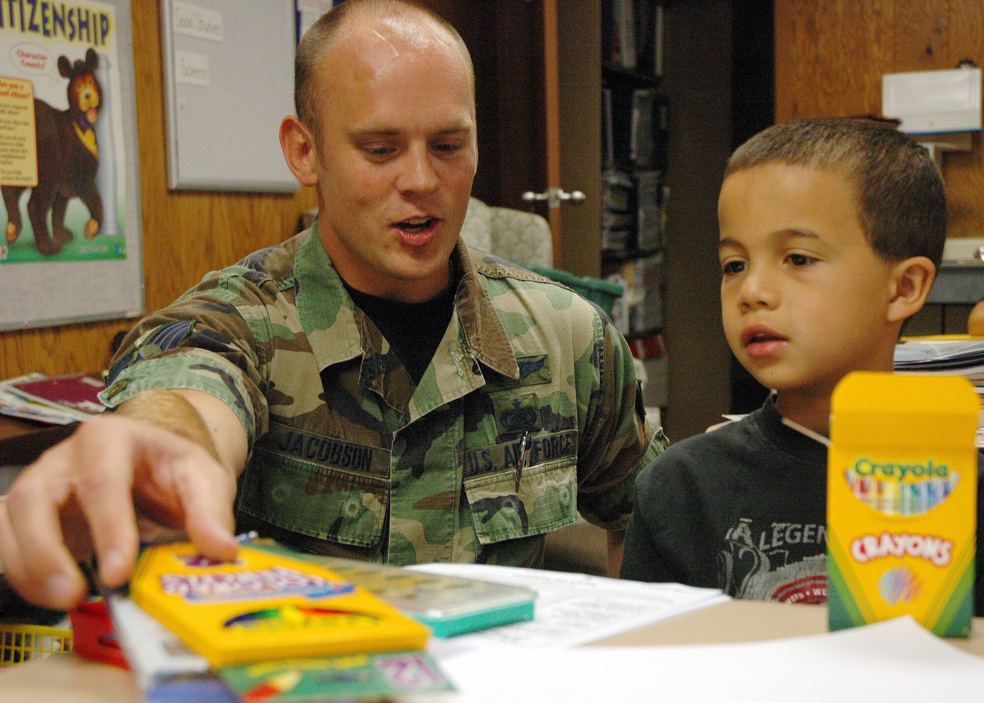 Staff Sgt. Brandon Jacobson presents new school supplies to 8-year-old Lorenso Carey Aug. 23 at Indian Hill Elementary School in Omaha, Neb. An Air Force Weather Agency team collected 200 pounds of assorted school supplies and delivered them to the school's children. Sergeant Jacobson is the NCO in charge of network infrastructure for AFWA's 2nd Systems Operations Squadron. (U.S. Air Force photo/G. A. Volb)
