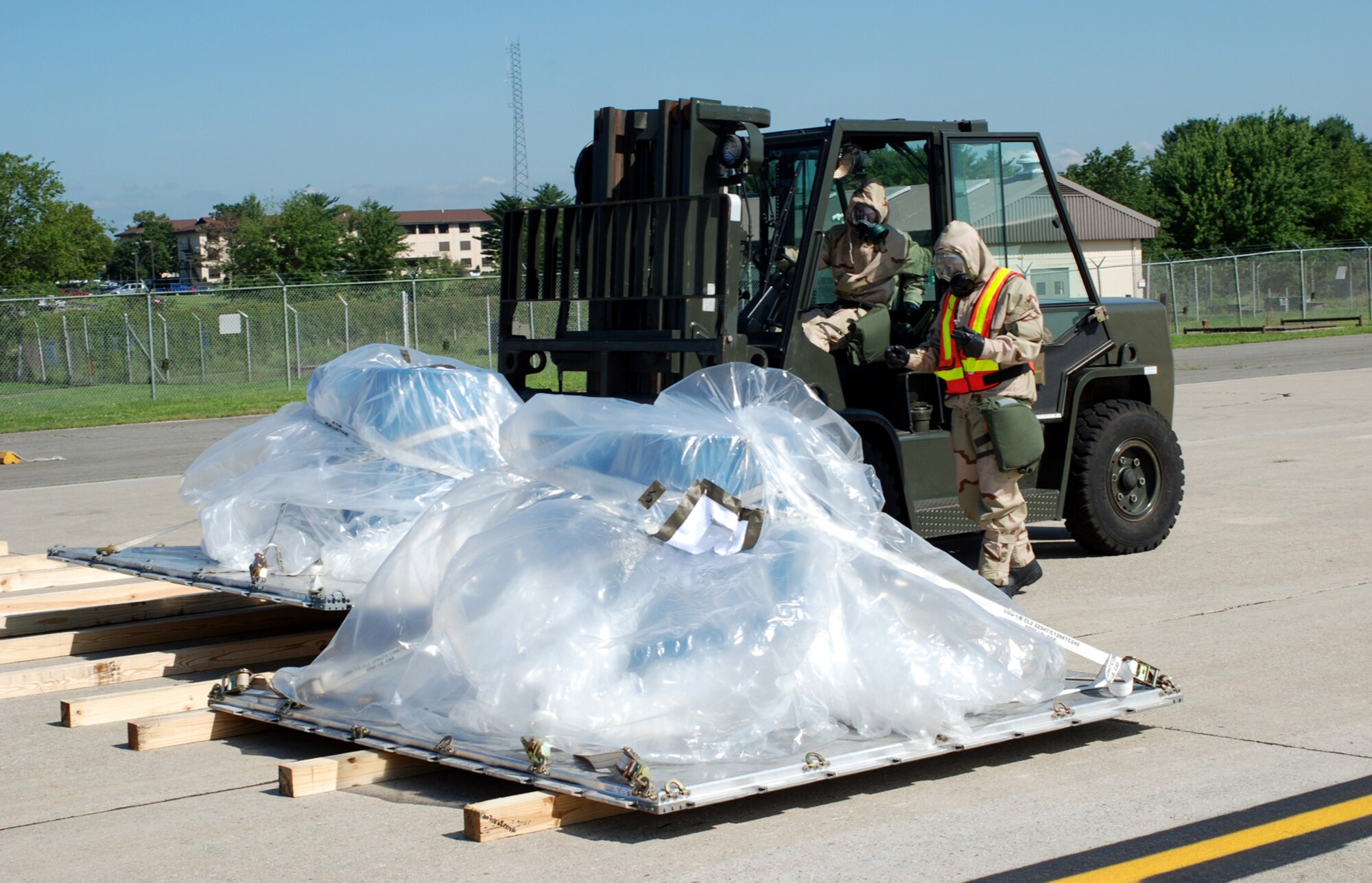 305th Aerial Port Squadron members prepare cargo to begin simulated Joint Chemical Agent Detector tests here Aug. 27. The tests will help the Air Force decide if the JCAD, used to detect nerve, blood and blister agents, will be used by personnel in the future. (U.S. Air Force photo/Airman 1st Class Rebekah Phy)