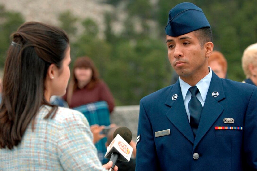 U.S. Air Force Airman First Class Joshua Ortiz-Mendoza, from the 28th Mission Support Group, Ellsworth Air Force Base, S.D., answers questions from a local news reporter after a naturalization ceremony at Mount Rushmore National Memorial, S.D., Aug. 23, 2007.  It took Airman Ortiz-Mendoza, originally from Peru, nearly two years and three different recruiters to finally get into the Air Force. (U.S. Air Force photo/Staff Sgt. Michael B. Keller)