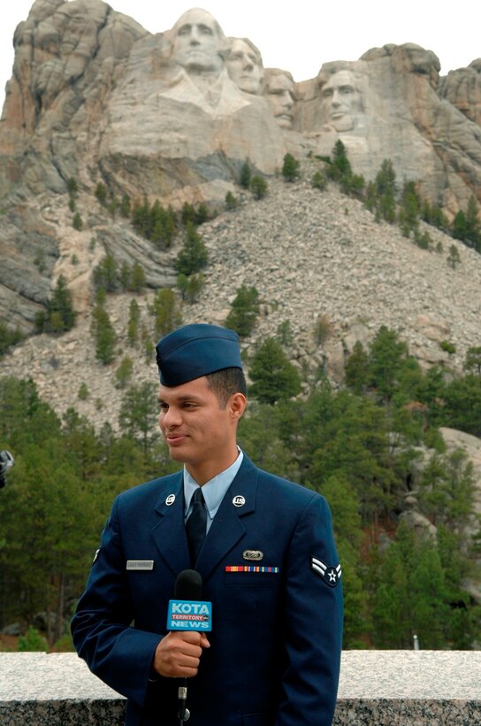 U.S. Air Force Airman First Class Santos Rodriguez, from the 28th Mission Support Group, Ellsworth Air Force Base, S.D., answers questions from a local news reporter after a naturalization ceremony at Mount Rushmore National Memorial, S.D., Aug. 23, 2007.  Airman Rodriguez, originally from Honduras, decided citizenship was something he should obtain after graduating Air Force basic military training. (U.S. Air Force photo/Staff Sgt. Michael B. Keller)