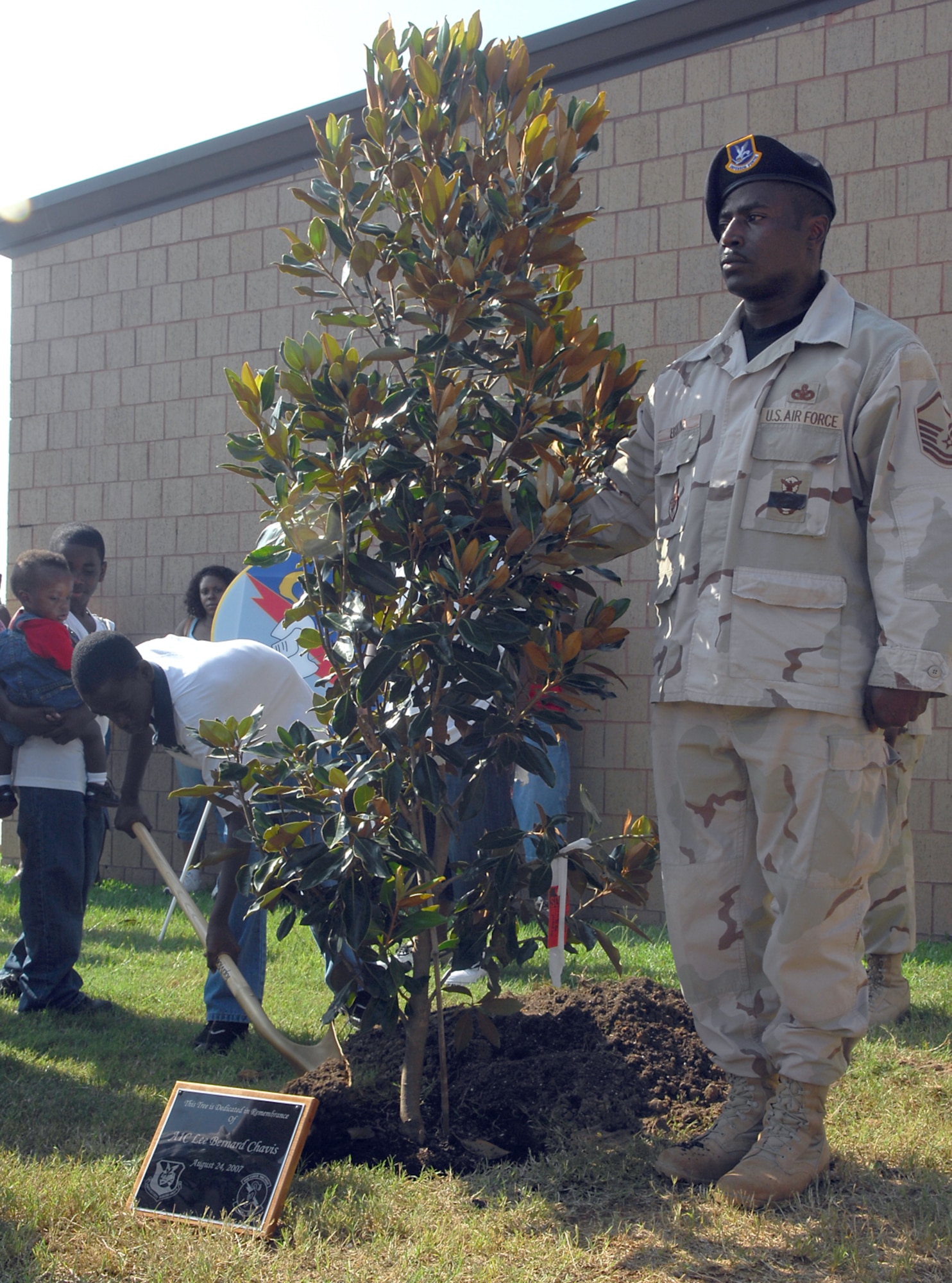Master Sgt. Anthony Erskine, 824th Security Forces Squadron, holds up a tree planted in Airman 1st Class LeeBernard Chavis' honor during a ceremony Aug. 24. The tree now stands at the entrance of the 824th SFS and represents the sacrifices Airman Chavis made defending his country. (U.S. Air Force photo by Senior Airman Angelita Lawrence)