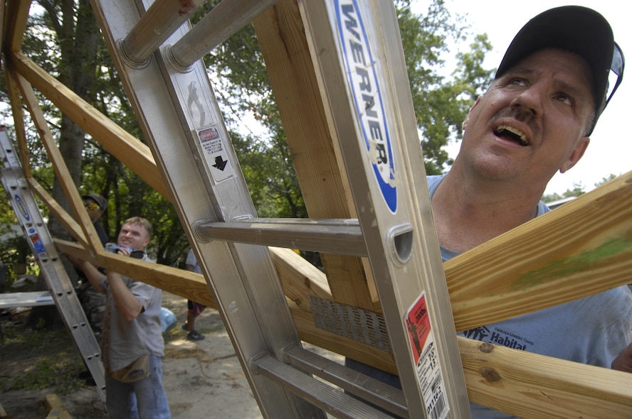 Senior Master Sgt. Brian Loisel (right), helps Staff Sgt. Jonathan Christian, and other members of Moody Air Force Base’s 23rd Civil Engineering Squadron, lift a section of roof framing onto a Habitat For Humanity home Aug. 13 in Valdosta Ga. Various squadrons from Moody volunteered their time during a week-long “blitz build.” (U.S. Air Force photo by Staff Sgt. Manuel J. Martinez)